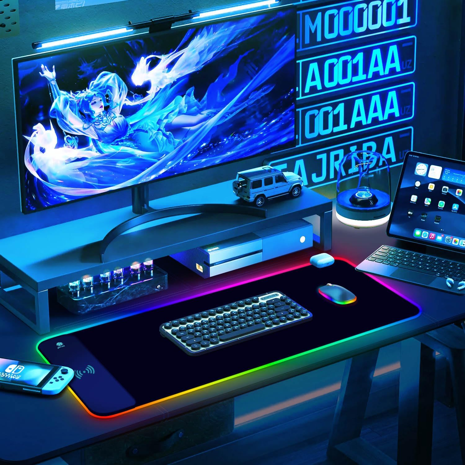 Una postazione da gioco con monitor grande, tastiera, mouse, Nintendo Switch e illuminazione RGB.