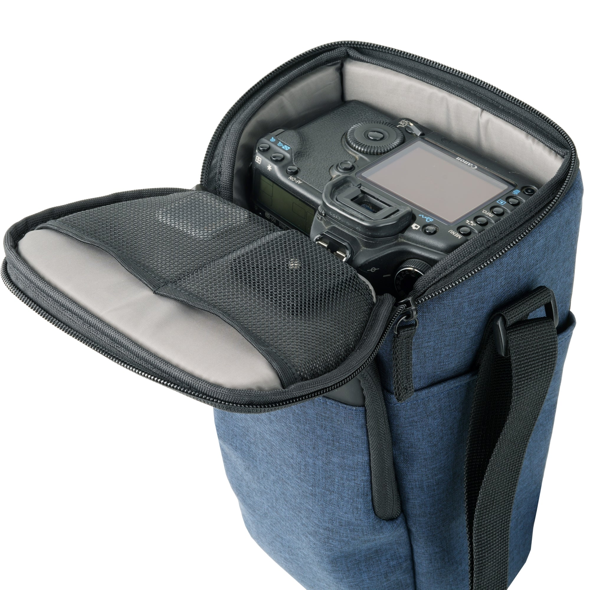 Una cámara DSLR dentro de un bolso de cámara azul abierto con bolsillo de malla.