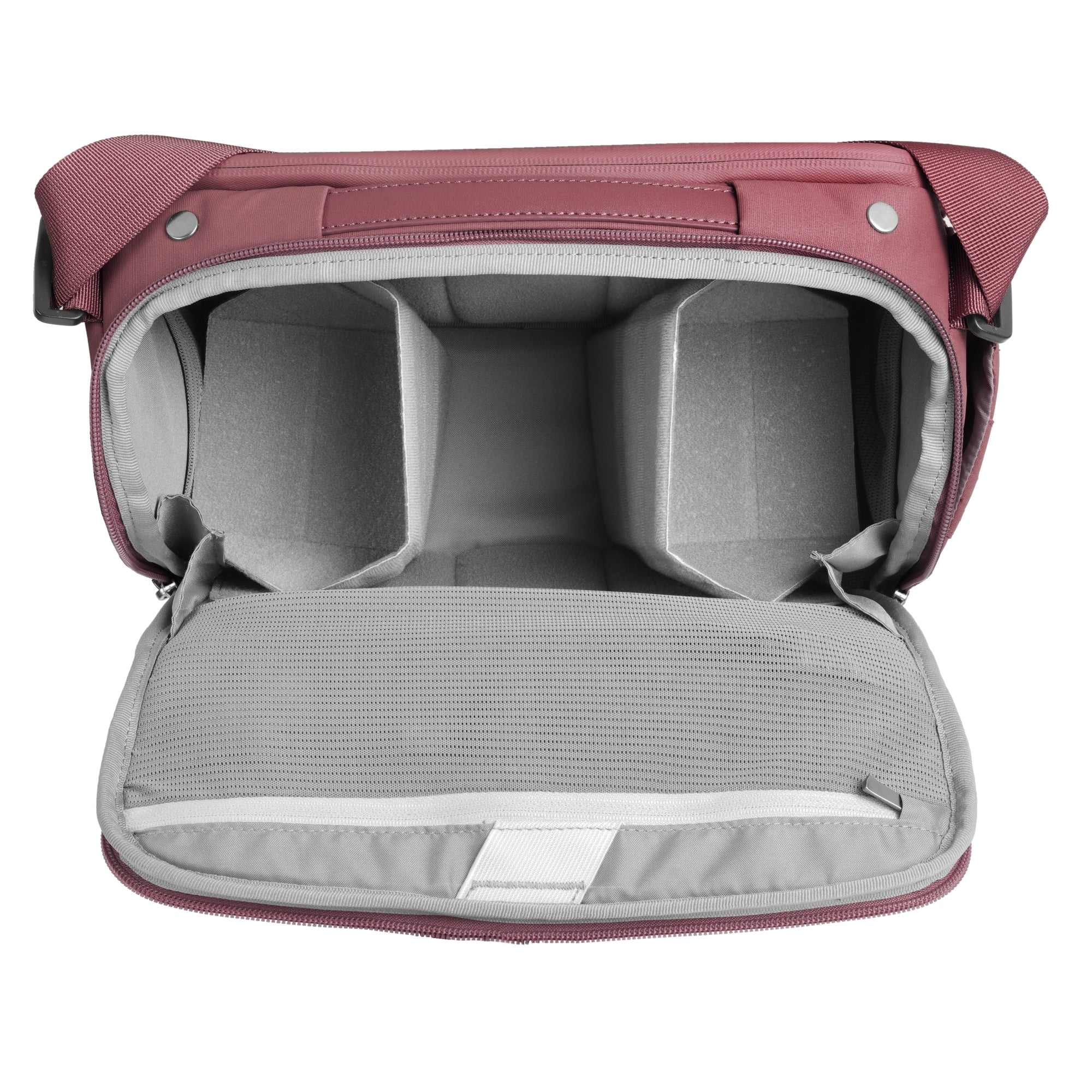 Una bolsa de cámara abierta, color rosa, con compartimentos acolchados y correa.