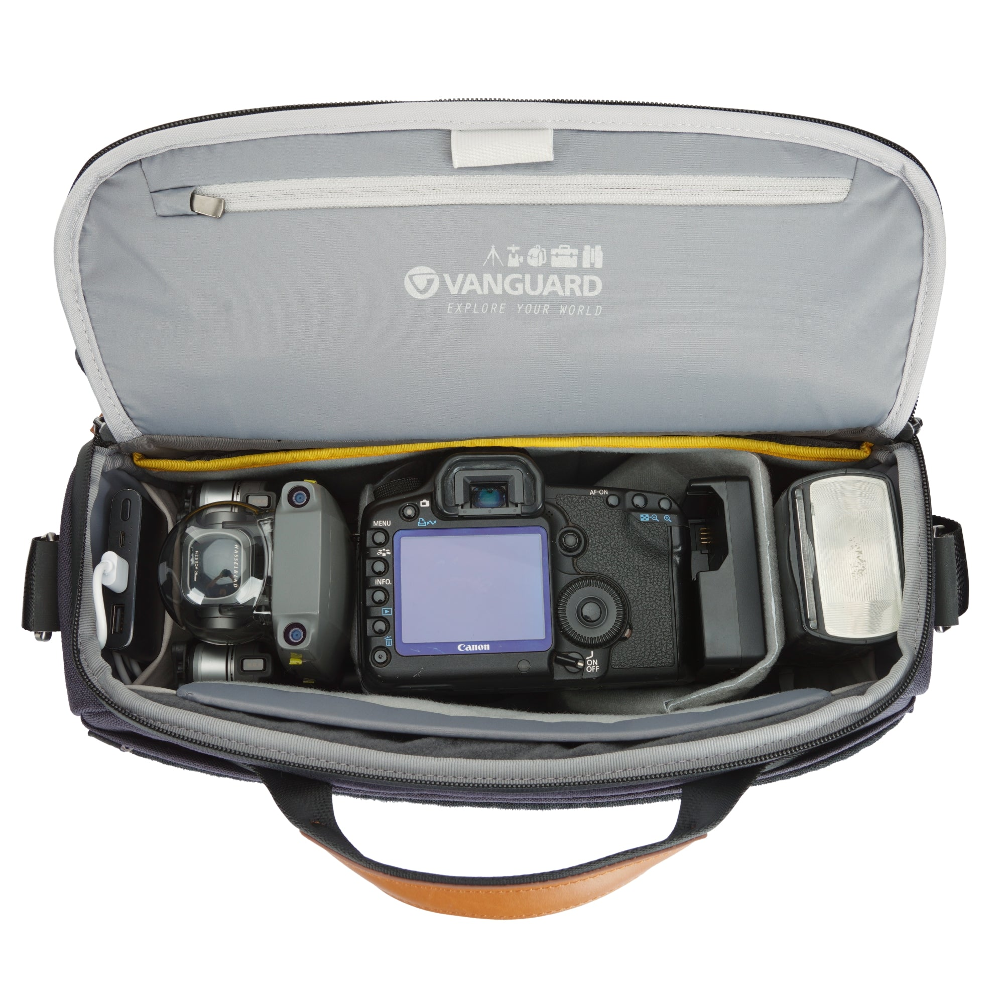 Bolso de cámara abierto con dron, Canon DSLR, flash y power bank.