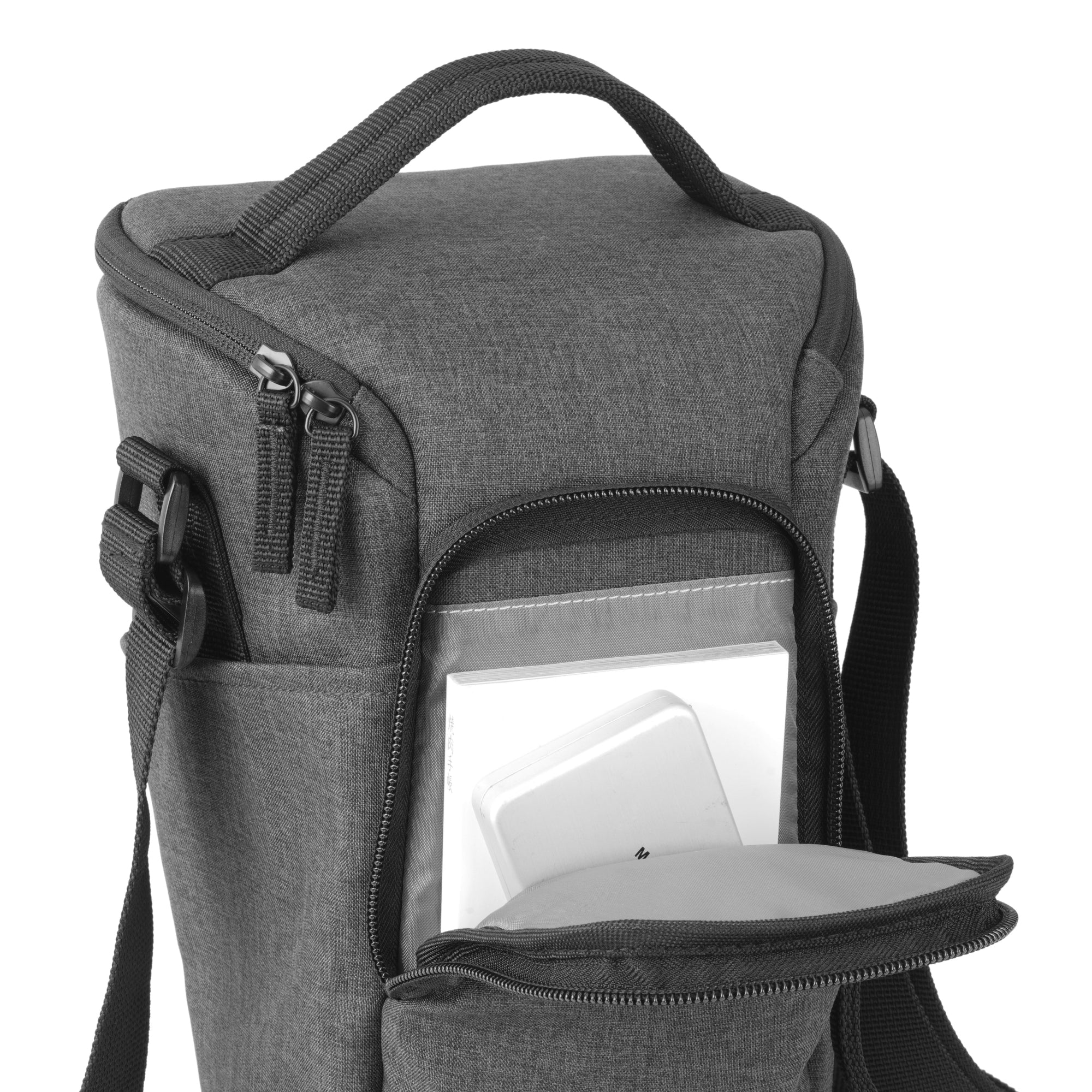 Bolso de cámara gris con bolsillo abierto que contiene un libro y un objeto blanco.