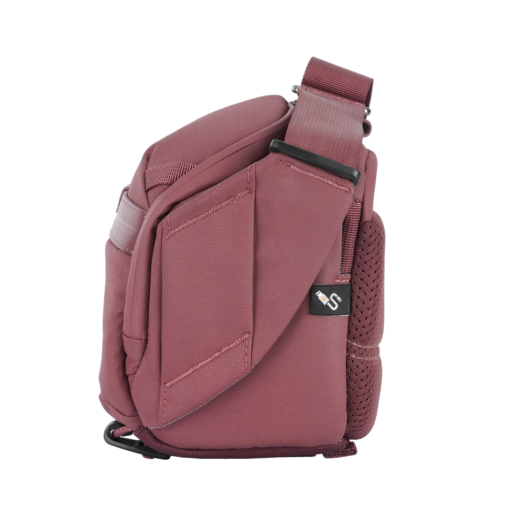 Un bolso cruzado color palo de rosa con correa ajustable y un pequeño logo.
