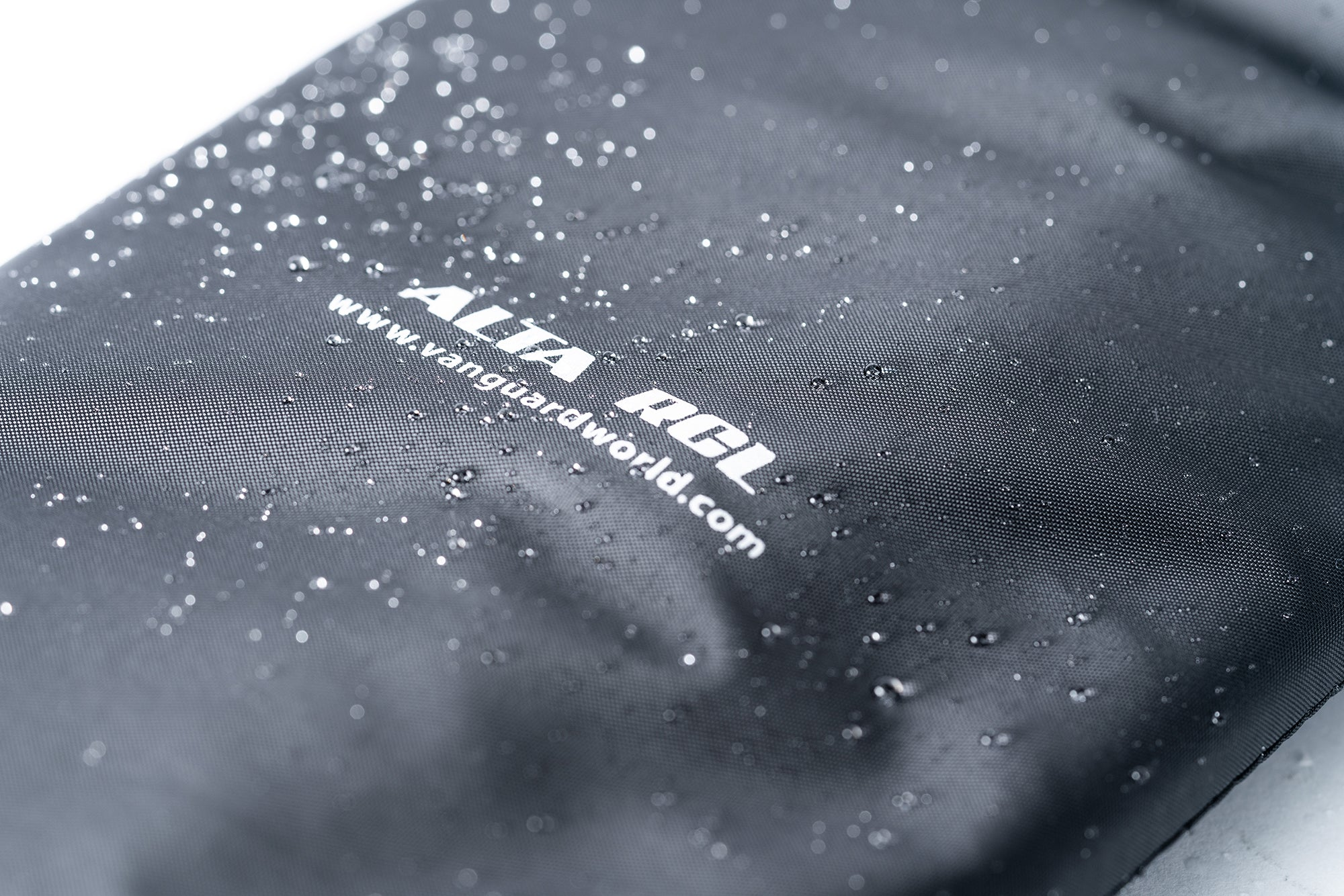 Superficie oscura con gotas de agua y logo blanco.