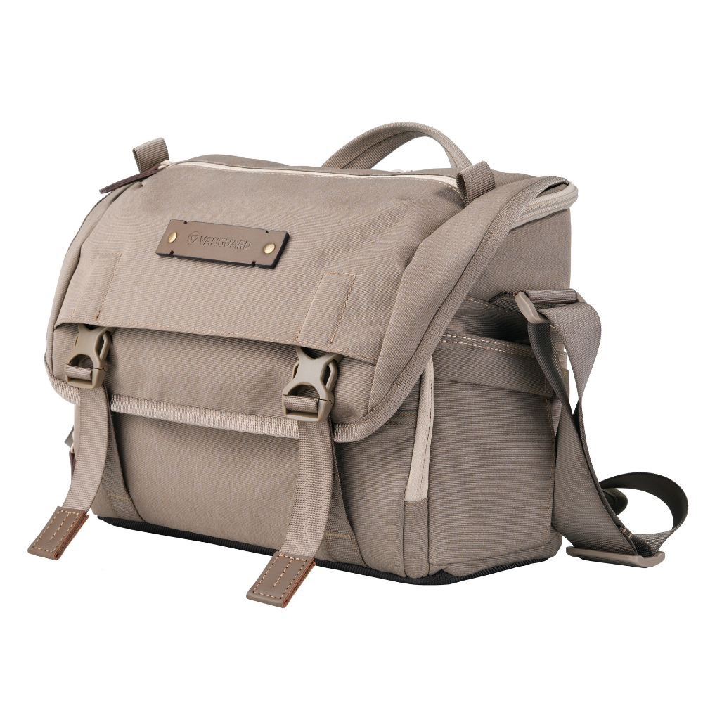 Bolso de cámara beige con detalles de cuero y hebillas.