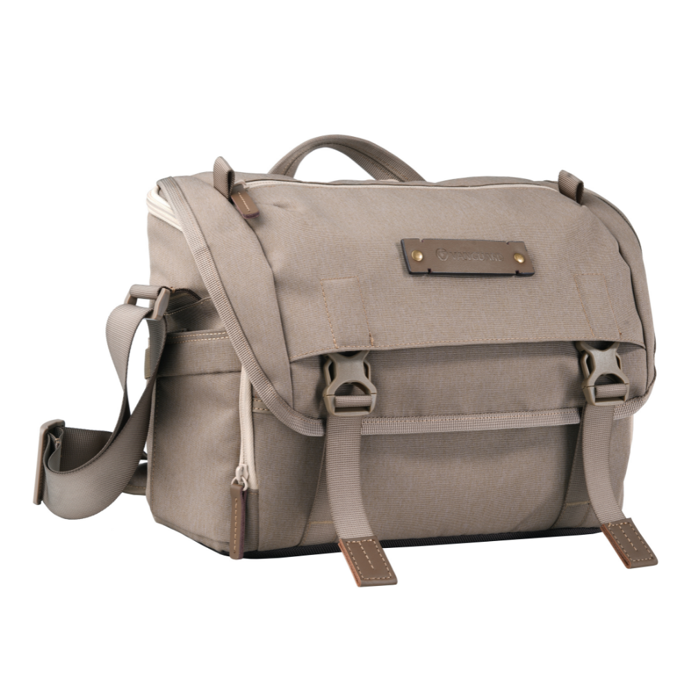 Bolso de cámara beige con detalles de cuero y hebillas.