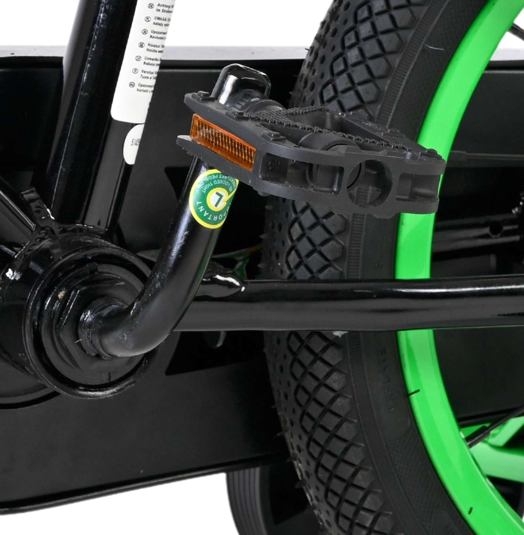Nahaufnahme des Fahrradpedals und Rads mit grünem Felge.