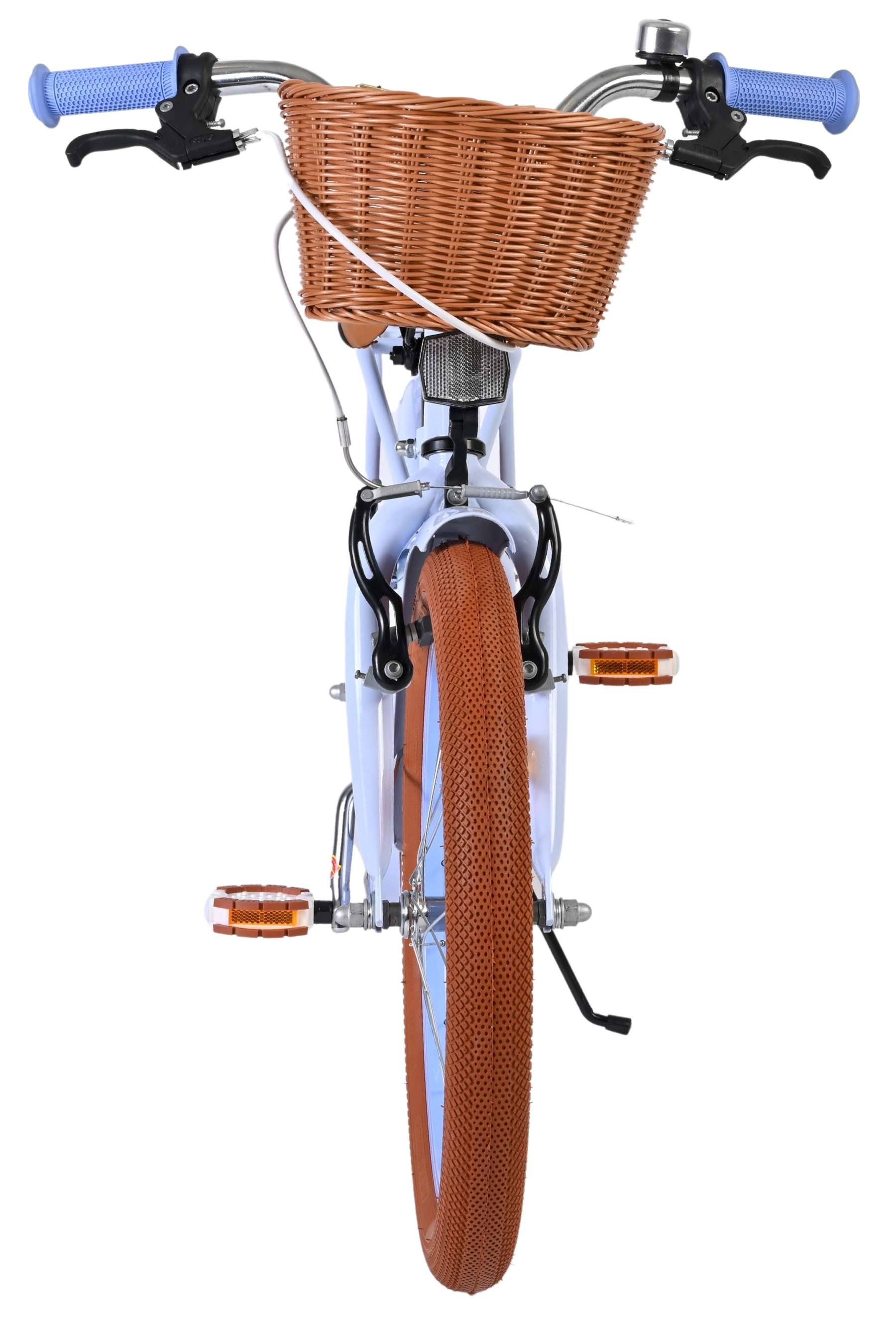 Ein weißes Kinderfahrrad mit braunem Korb und braunen Reifen.