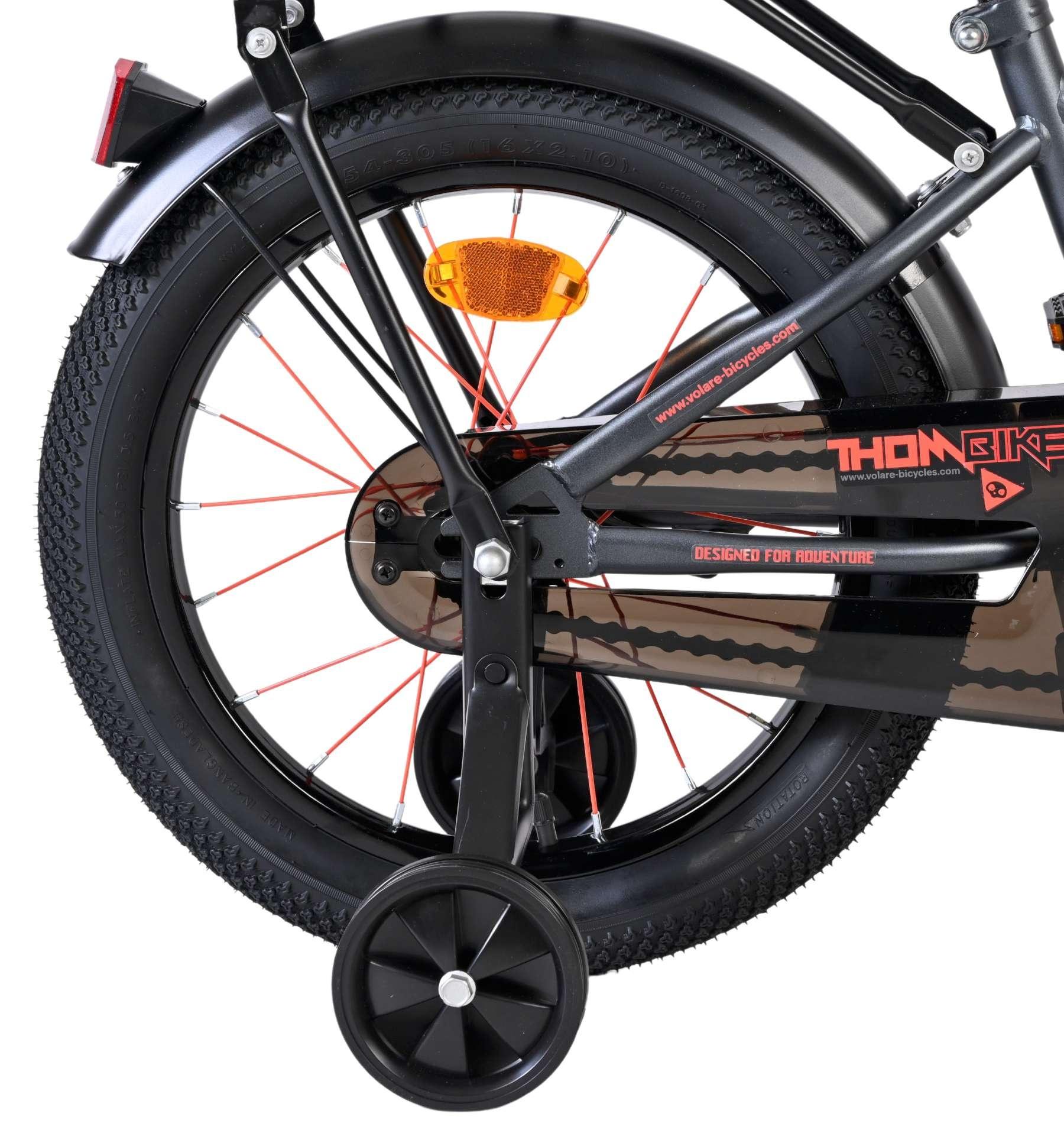 Detailansicht eines Fahrrad-Hinterrads mit Stützrädern, roter Speiche und Kettenschutz.