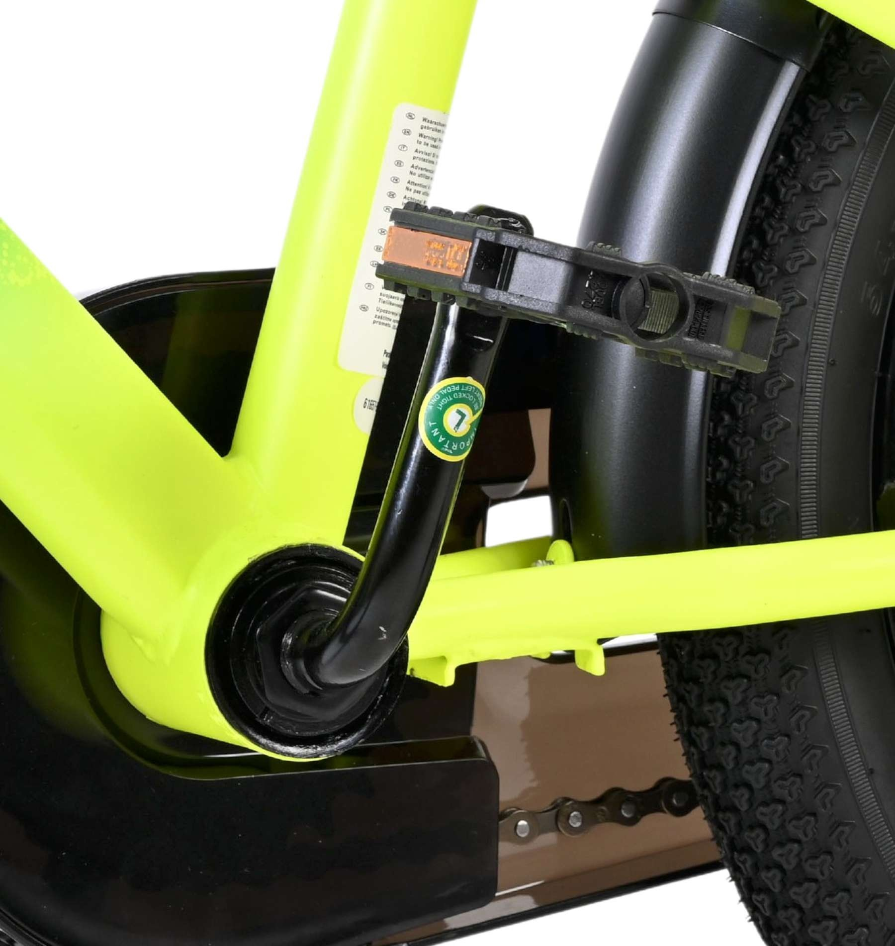 Nahaufnahme eines Fahrradpedals und des gelben Rahmens. Kette sichtbar.