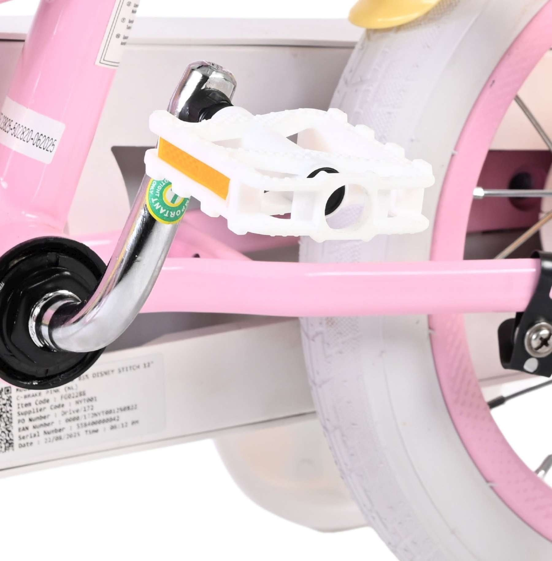 Nahaufnahme des weißen Pedals, des Chrom-Kurbelarms und eines Teils des Rades eines pinken Fahrrads.