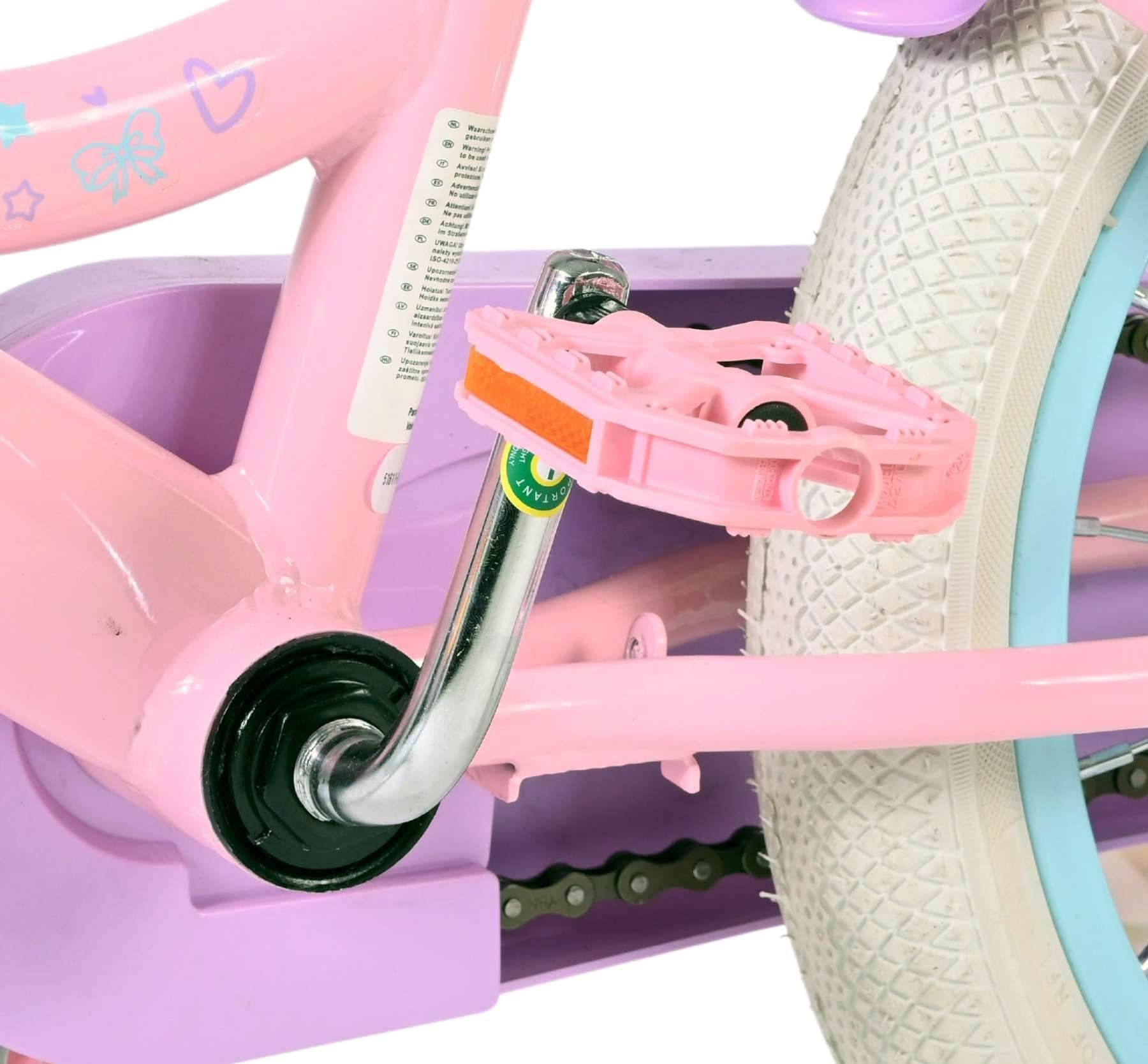 Nahaufnahme eines rosa Kinderfahrrads mit Pedalen, Kette und Rad.