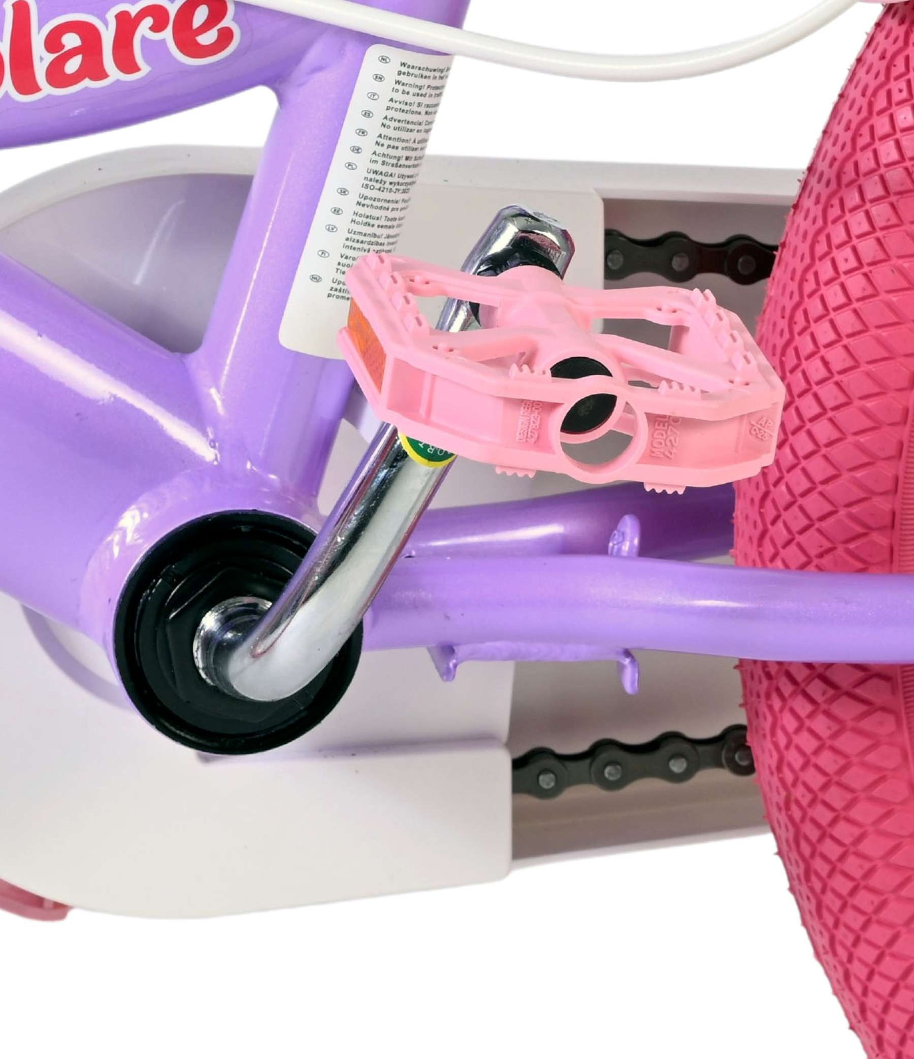 Nahaufnahme eines pinken Fahrradpedals, einer Kette und eines Rades.