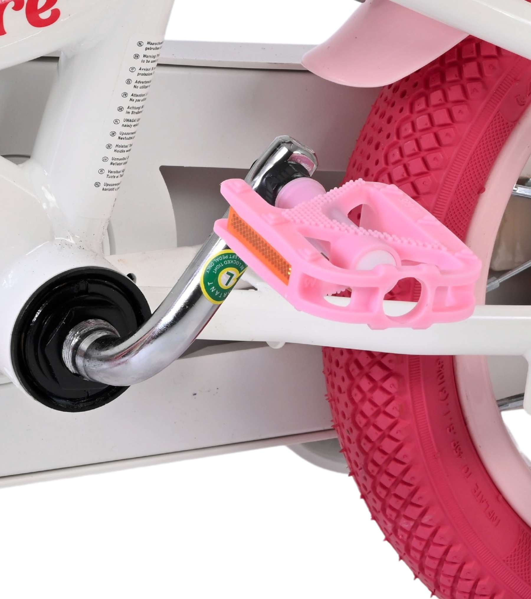 Nahaufnahme eines Fahrradpedals und eines pinken Reifens mit Warnhinweisen.