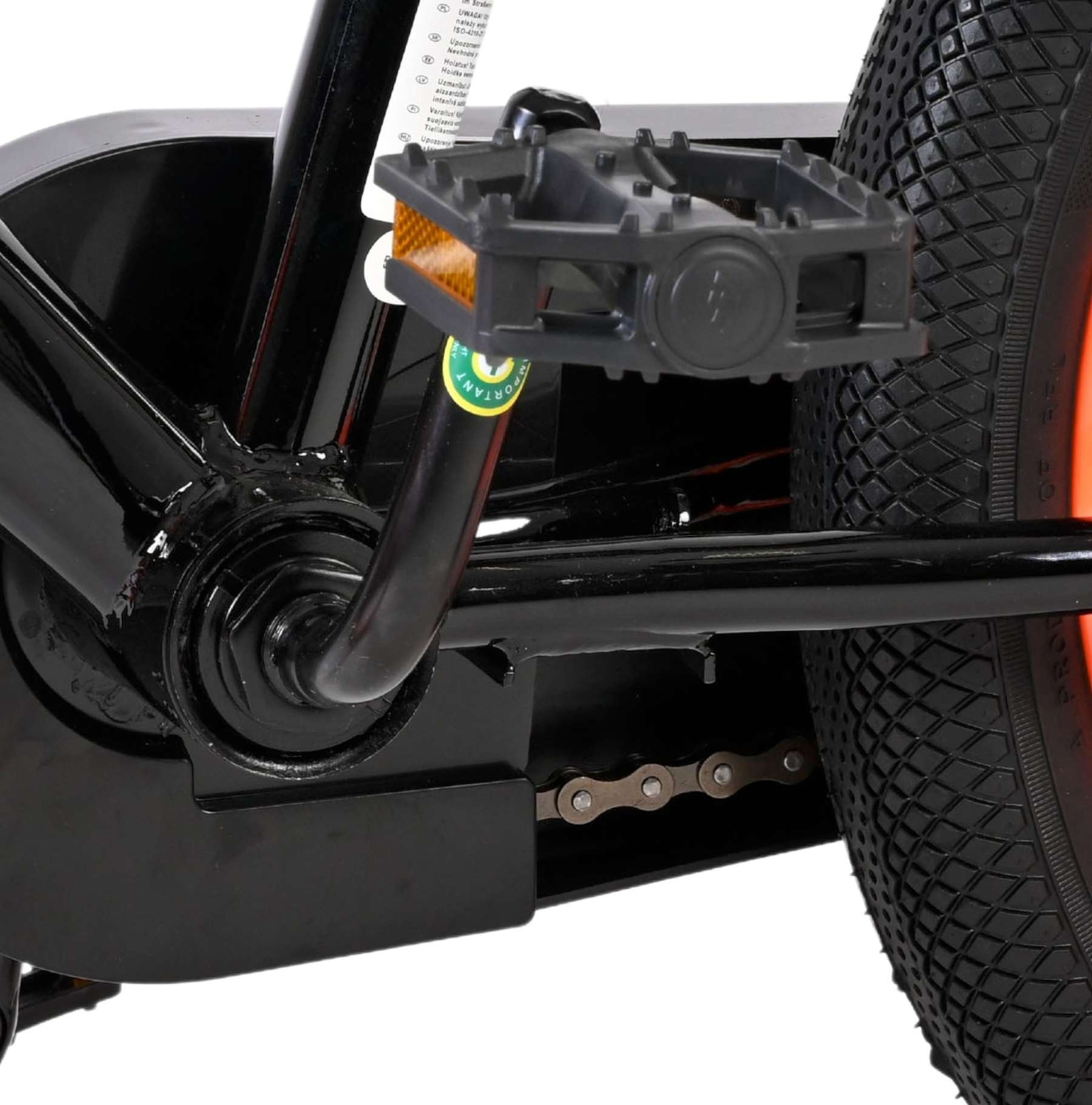 Nahaufnahme des Fahrradpedals, der Kette und des Reifens. Schwarz und Grau.