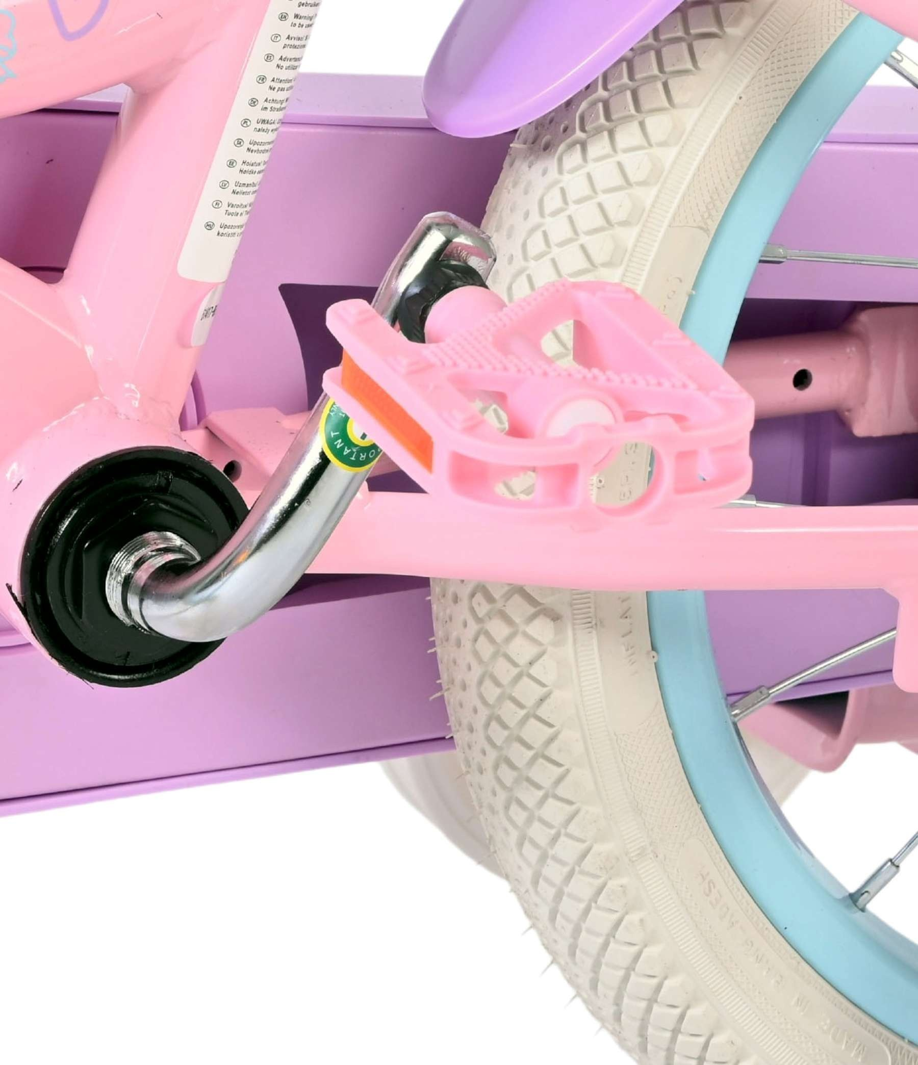 Nahaufnahme eines rosa Kinderfahrrads mit pinkfarbenen Pedalen und einem weißen Reifen.