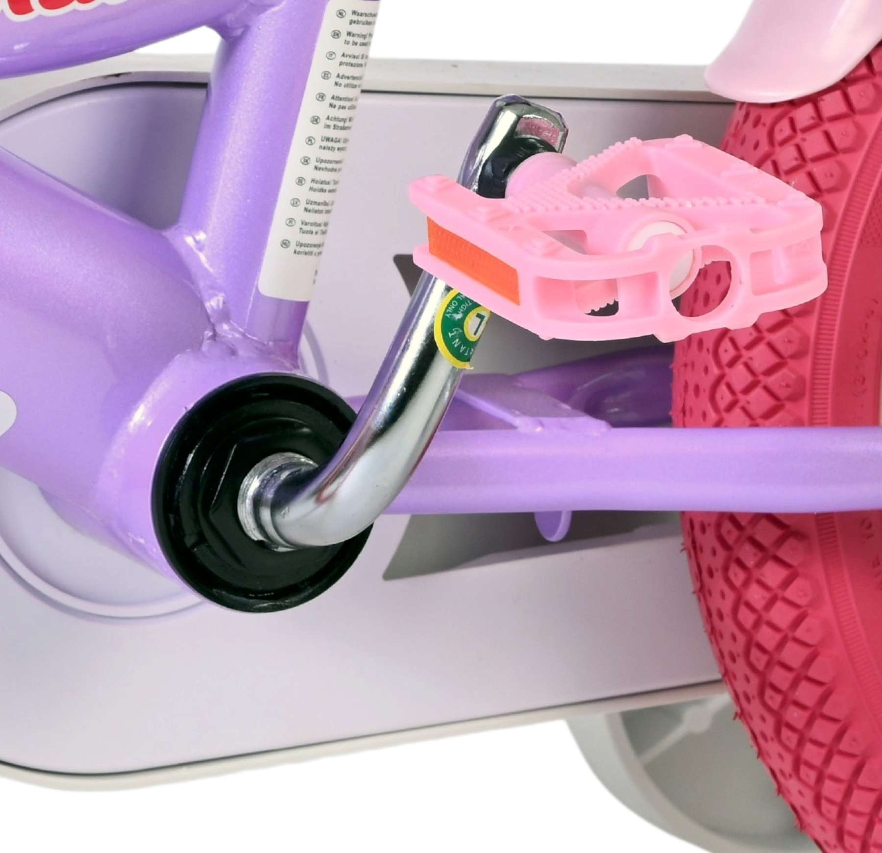 Nahaufnahme eines pinken Fahrradpedals mit violettem Rahmen und rotem Rad.