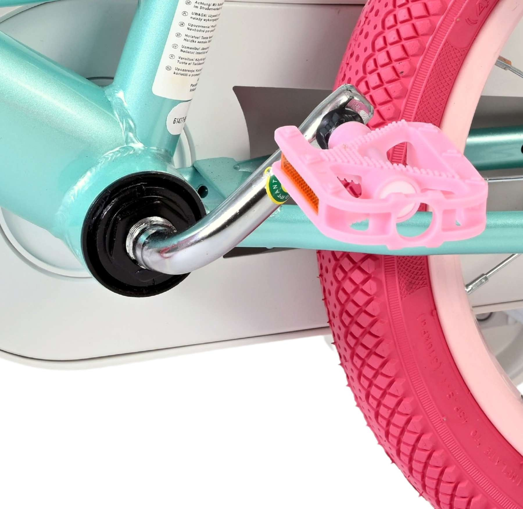 Detailaufnahme eines türkisfarbenen Fahrradrahmens mit einem rosa Pedal und Rad.