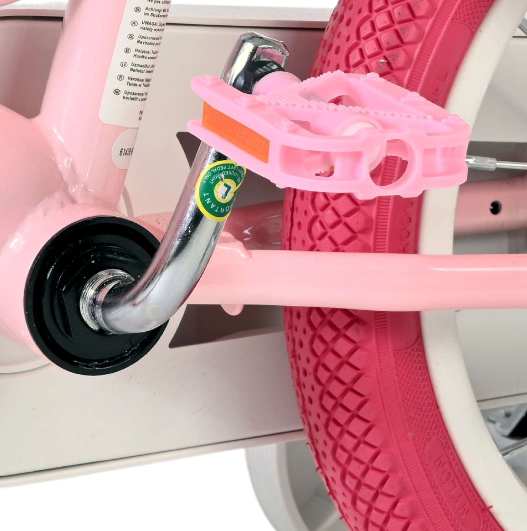 Rosa Fahrradpedale und Reifen mit weißer Felge. Nahaufnahme.