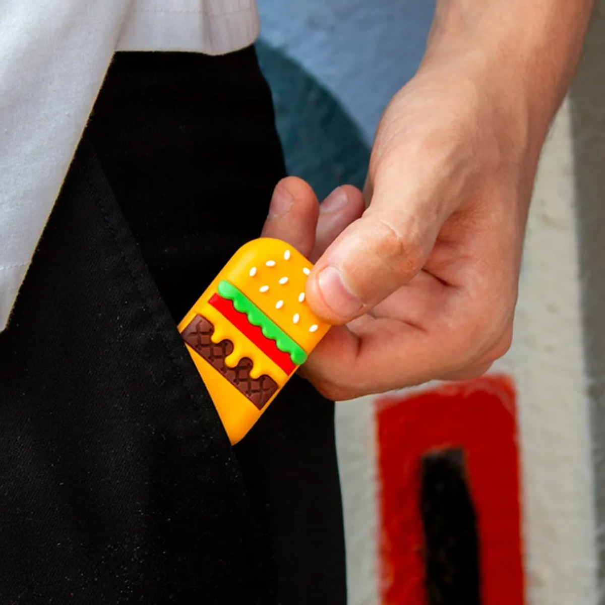 Un portachiavi a forma di hamburger viene messo in una tasca nera.