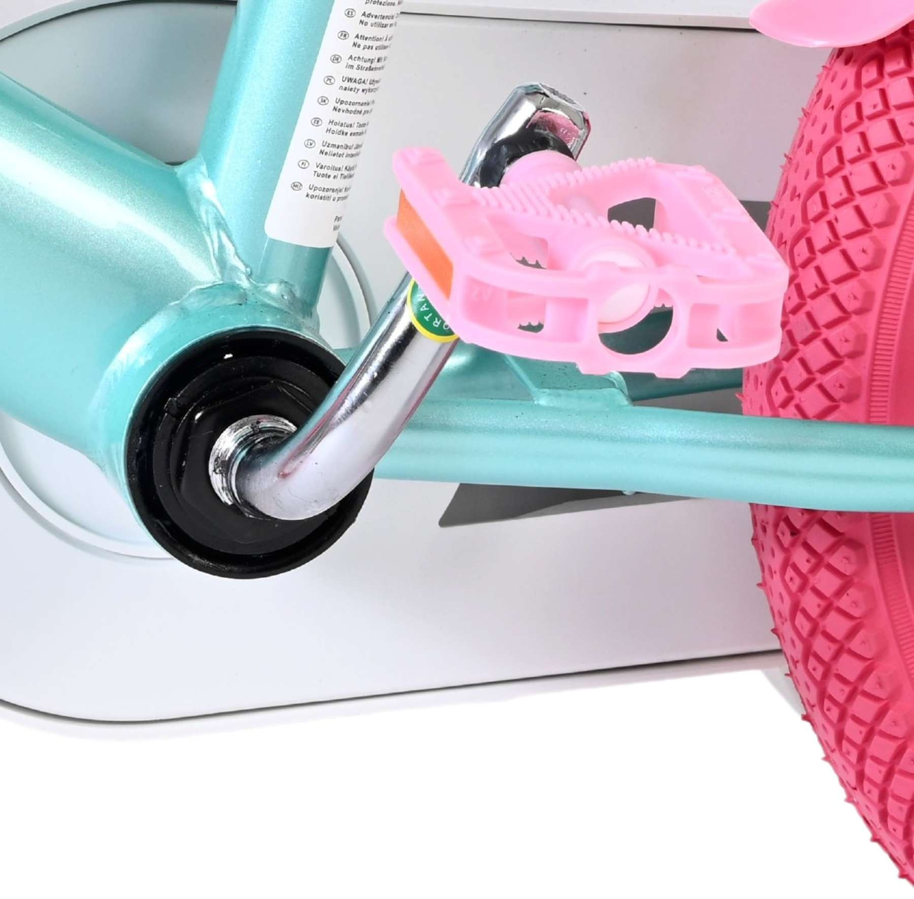Ein türkisfarbener Fahrradrahmen mit rosa Pedalen und einem rosa Rad.