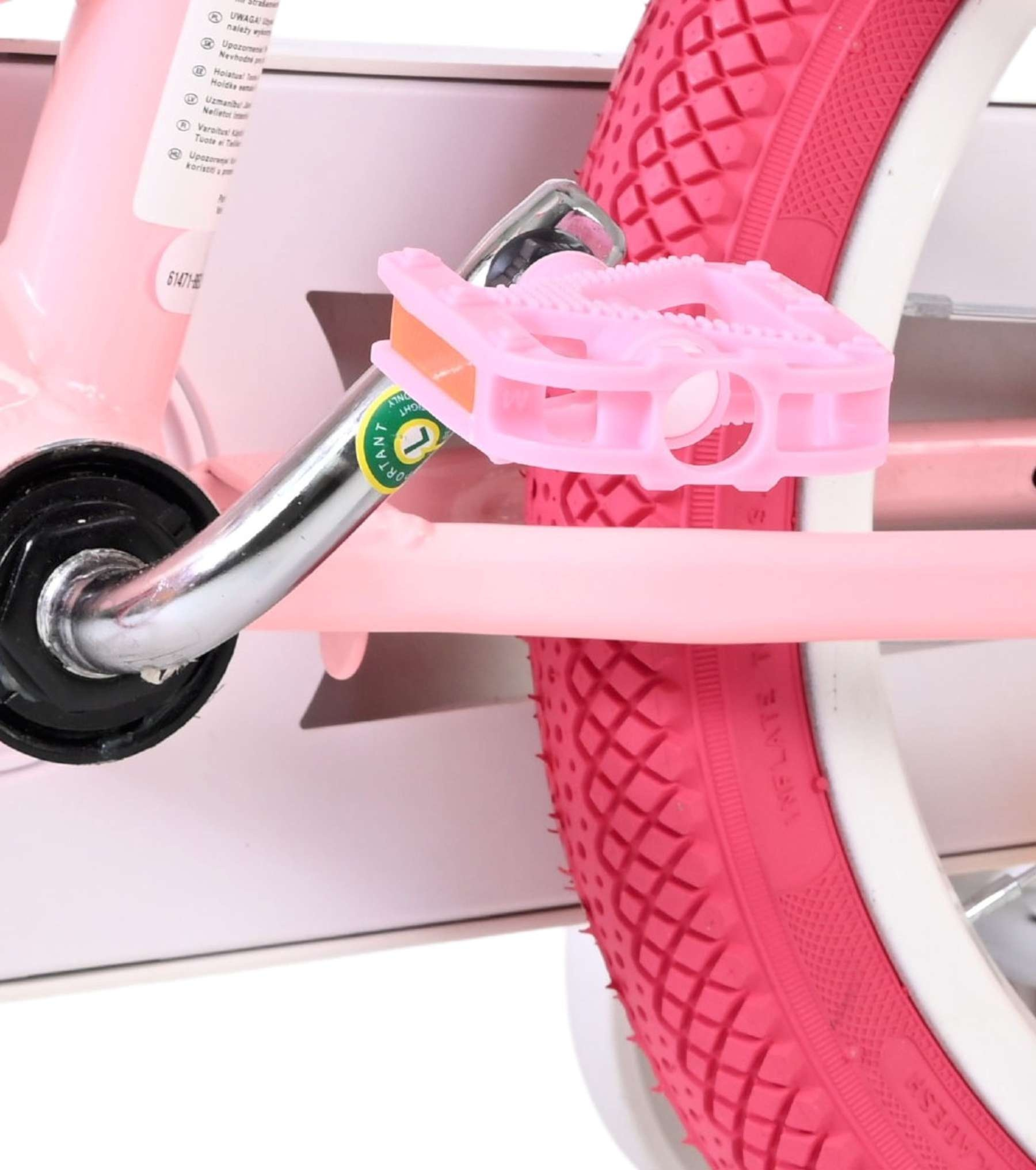 Nahaufnahme eines rosa Fahrradpedals und Reifens auf einem Kinderfahrrad.