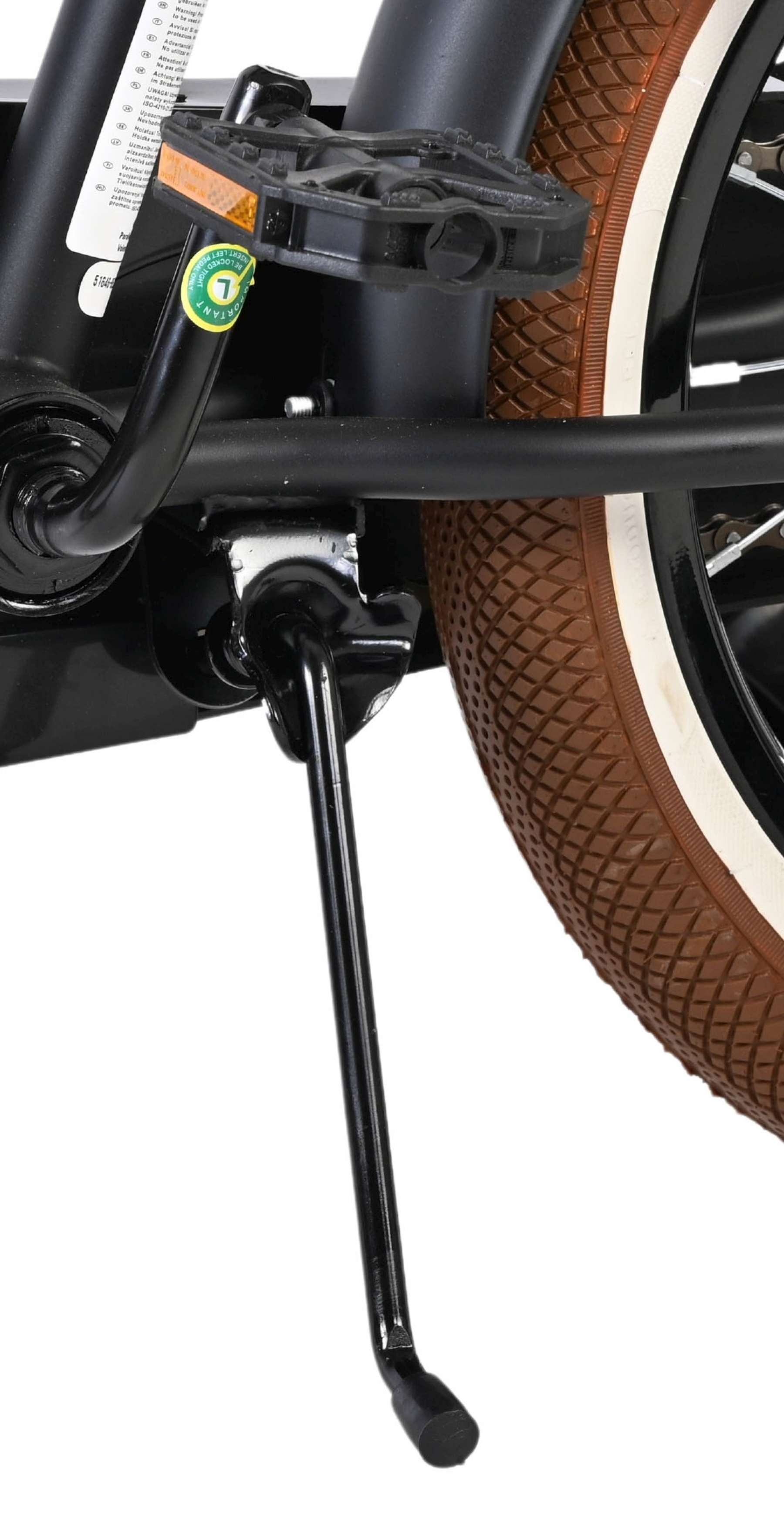 Nahaufnahme des Fahrradständers, Pedals und braunen Reifens mit weißem Rand.