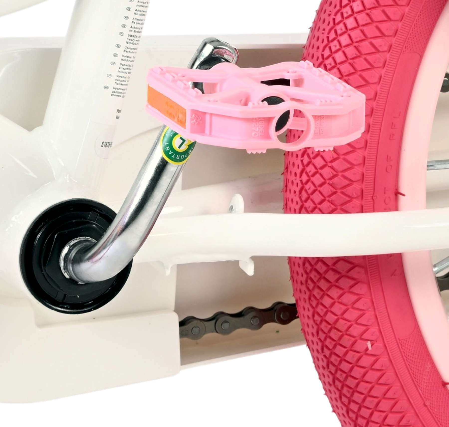 Nahaufnahme eines Fahrradpedals und eines pinken Reifens mit Kette.