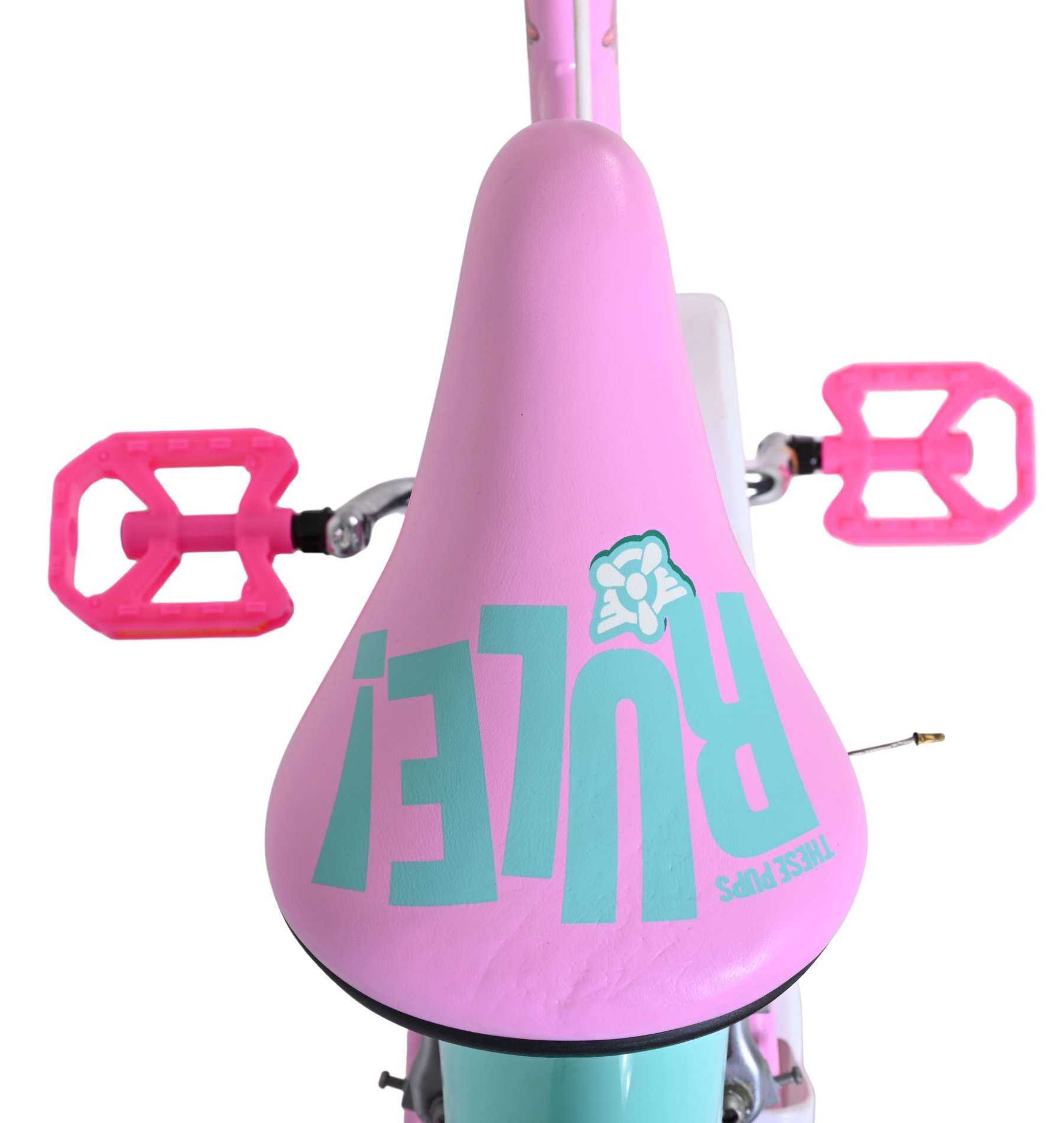 Ein rosa Fahrradsitz mit türkisfarbener Schrift und pinken Pedalen.
