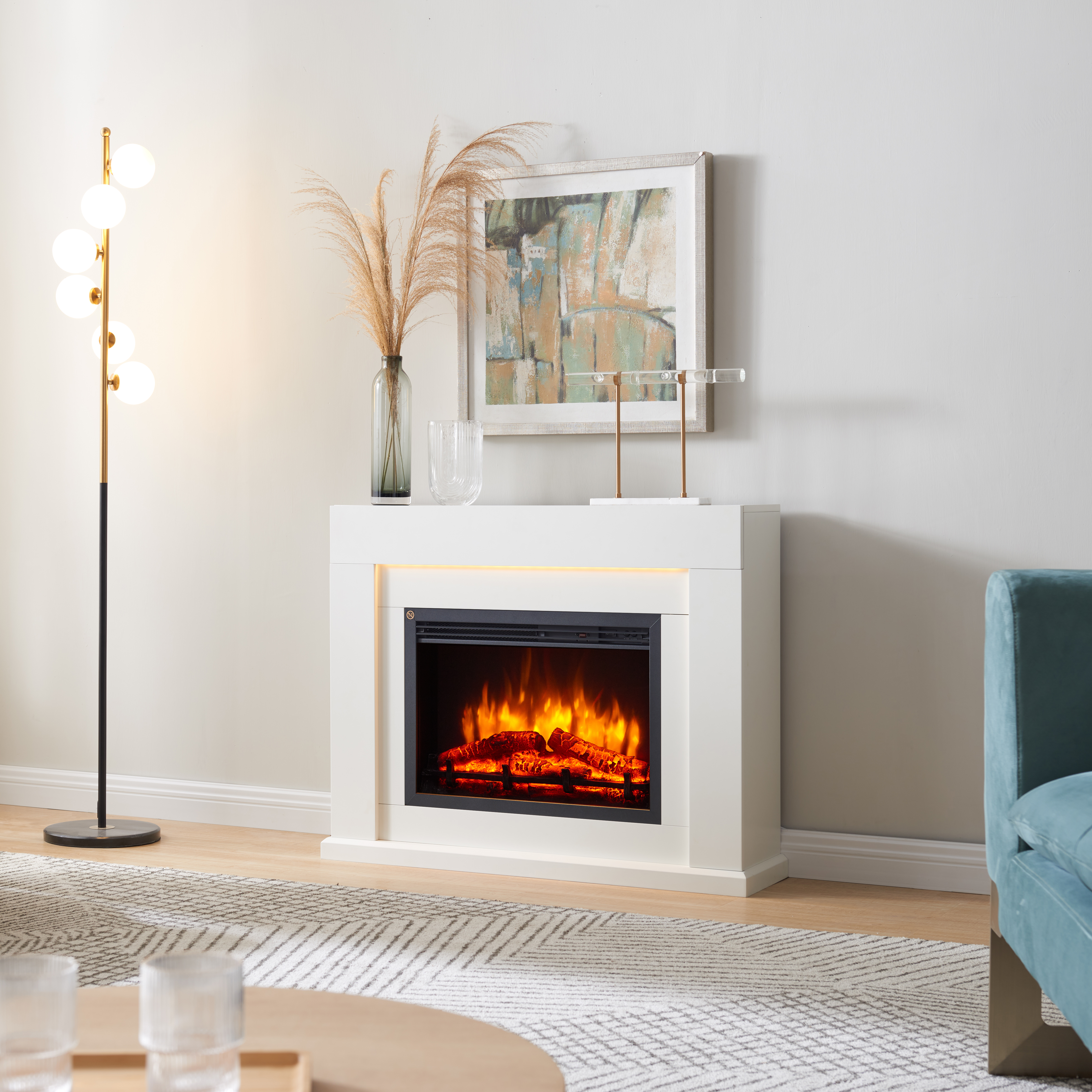 Ein weißer Kamin mit Flammen, daneben eine Stehlampe und ein Kunstwerk.