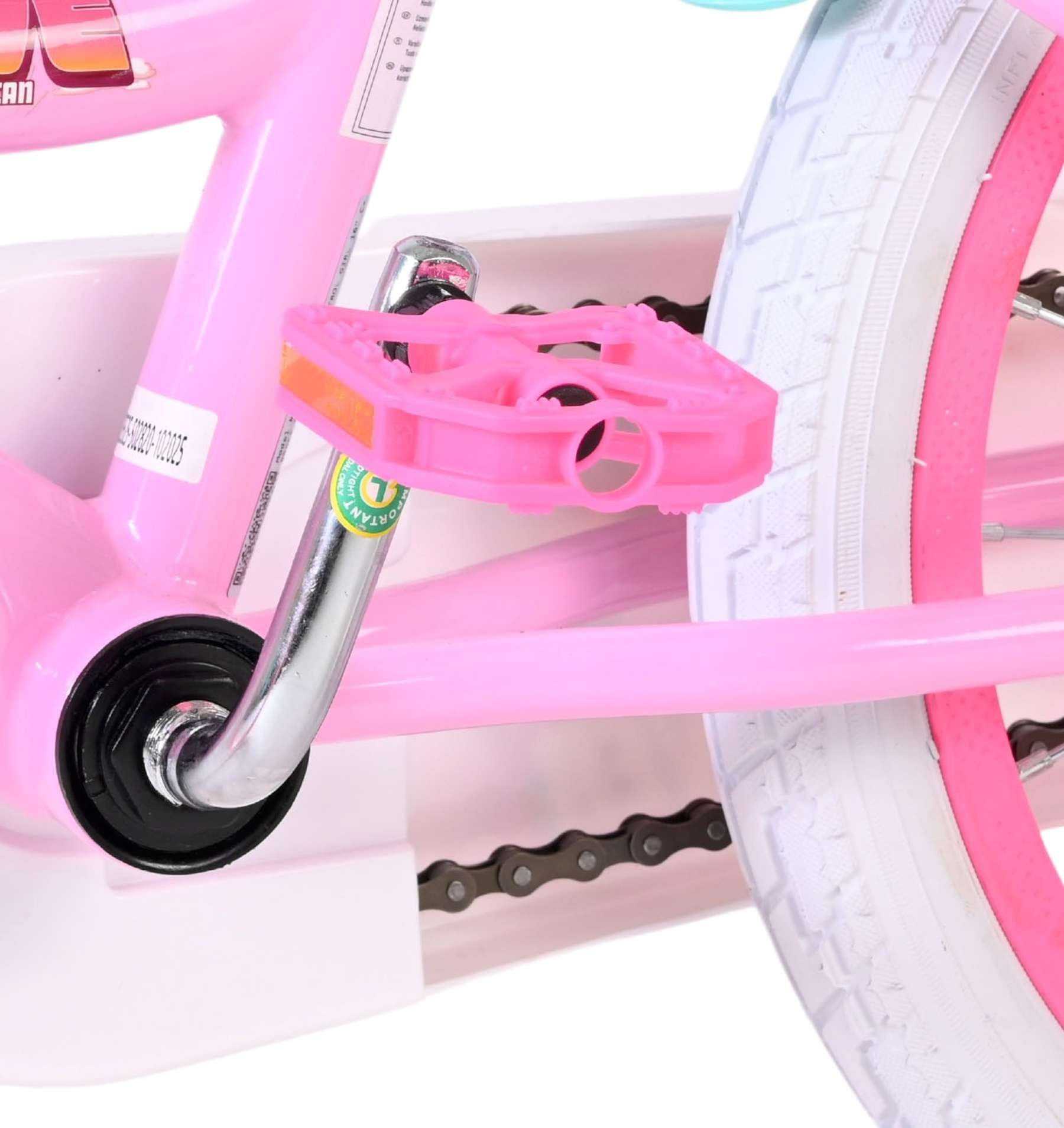 Nahaufnahme eines rosa Kinderfahrrads mit Pedalen, Kette und weißem Reifen.
