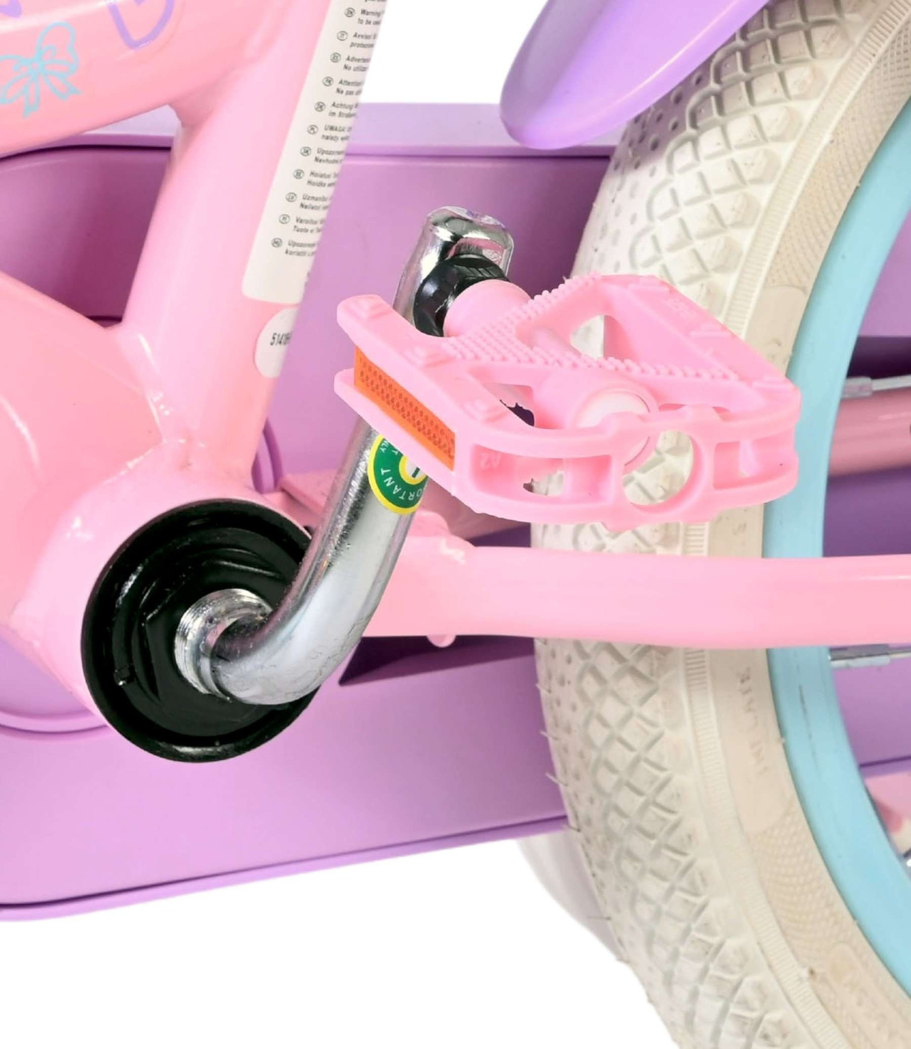Nahaufnahme eines pinken Kinderfahrrads mit Pedalen, Rad und lila Schutzblech.