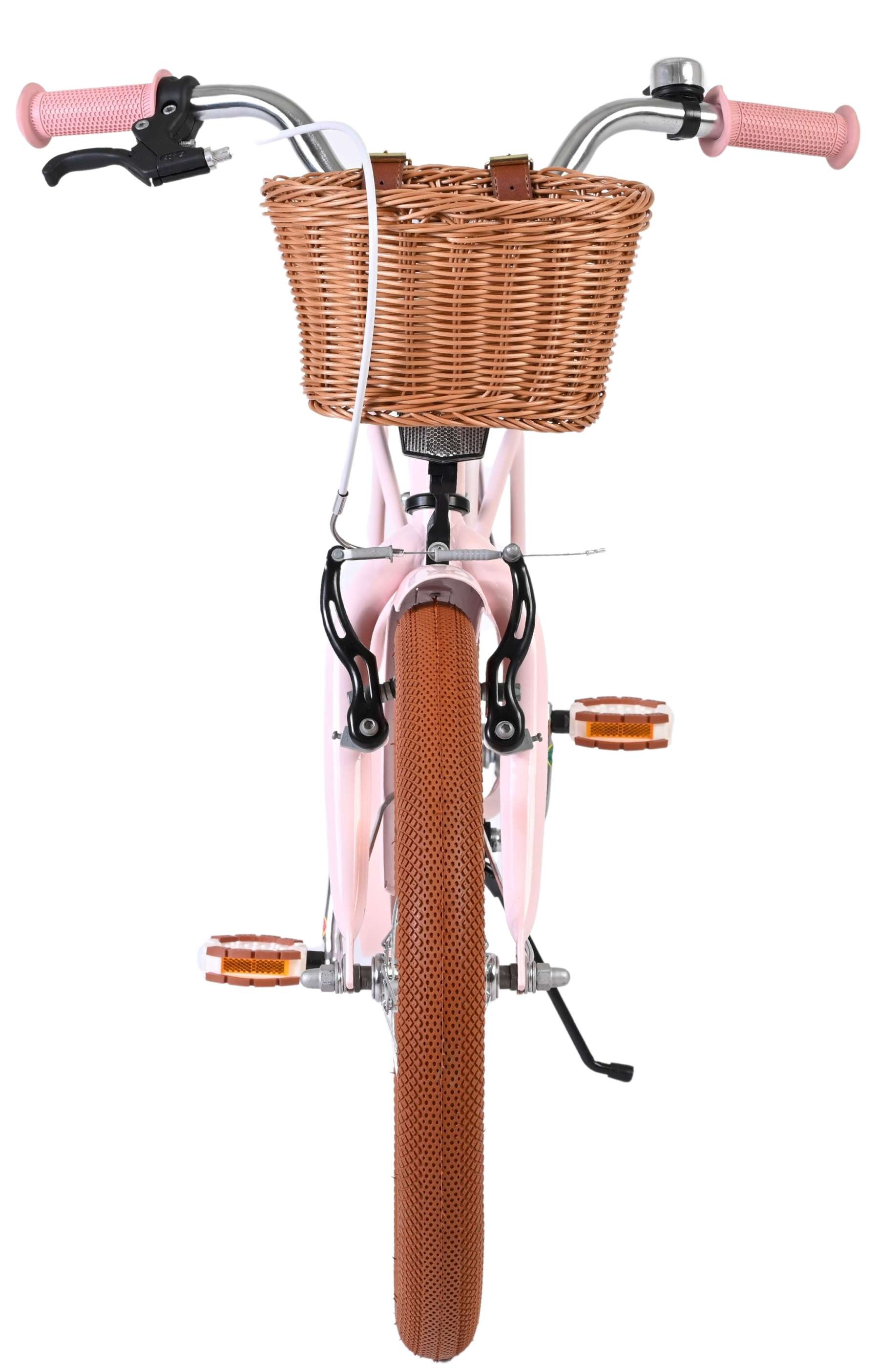 Ein rosafarbenes Kinderfahrrad mit einem Korbfach vorn und braunen Rädern.