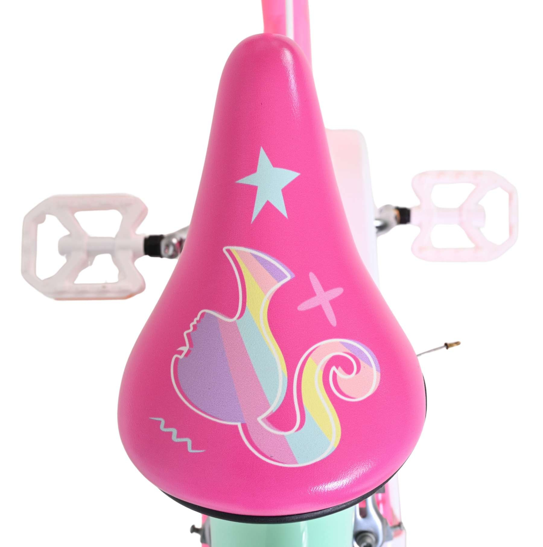 Ein pinker Fahrradsitz mit Einhorn- und Sternenmotiv, daneben weiße Pedale.
