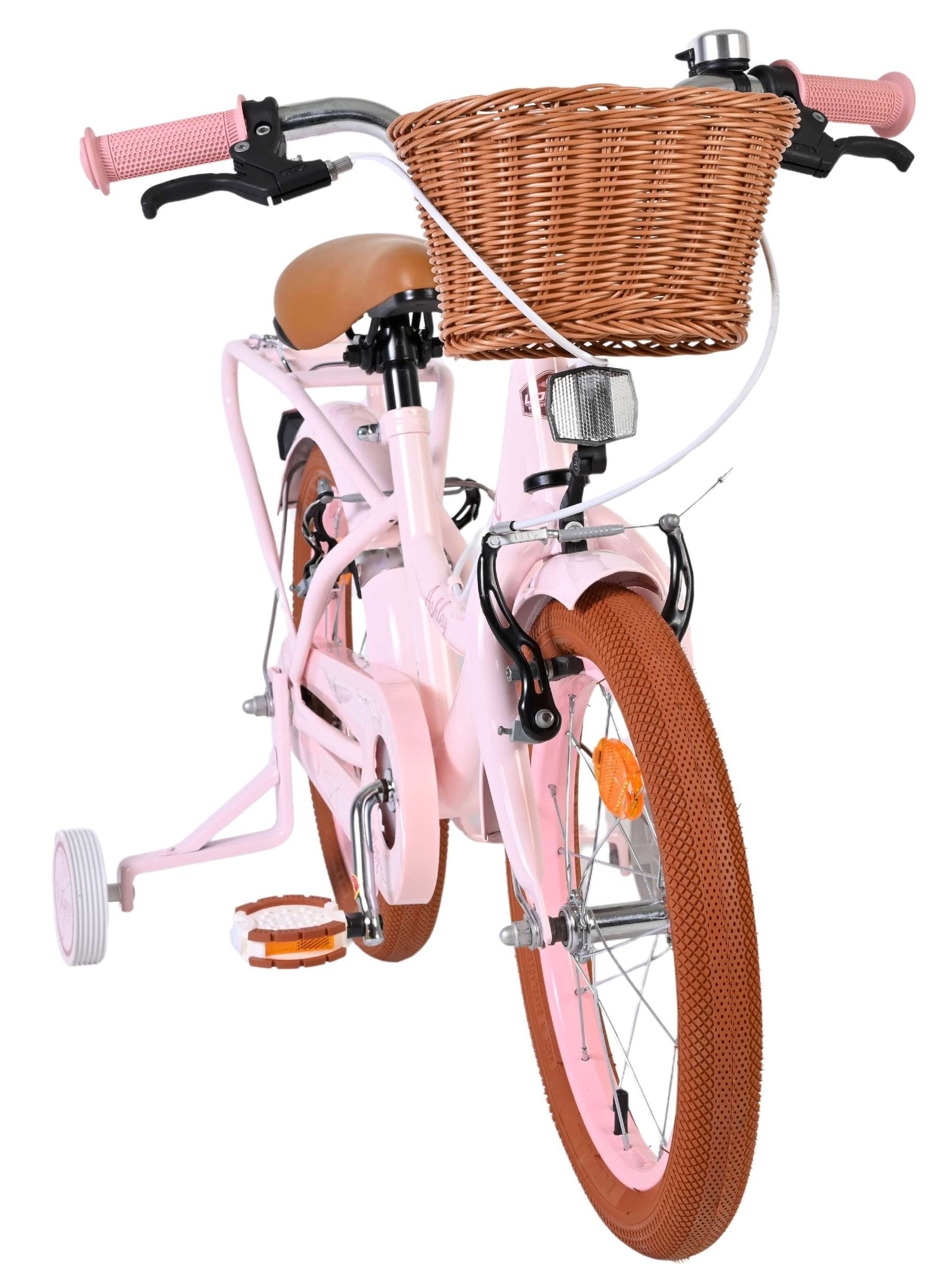 Ein rosafarbenes Kinderfahrrad mit braunem Korb, braunem Sattel und Stützrädern.