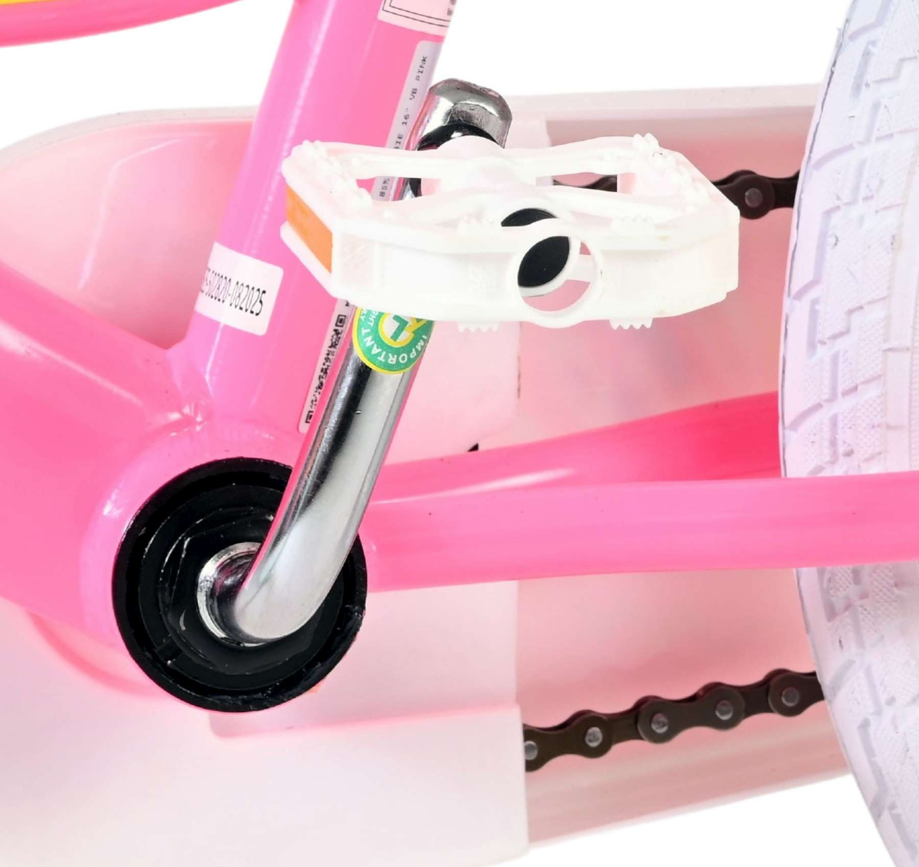 Nahaufnahme des rosa Dreirad-Tretkurbelmechanismus mit weißem Pedal und Kette.