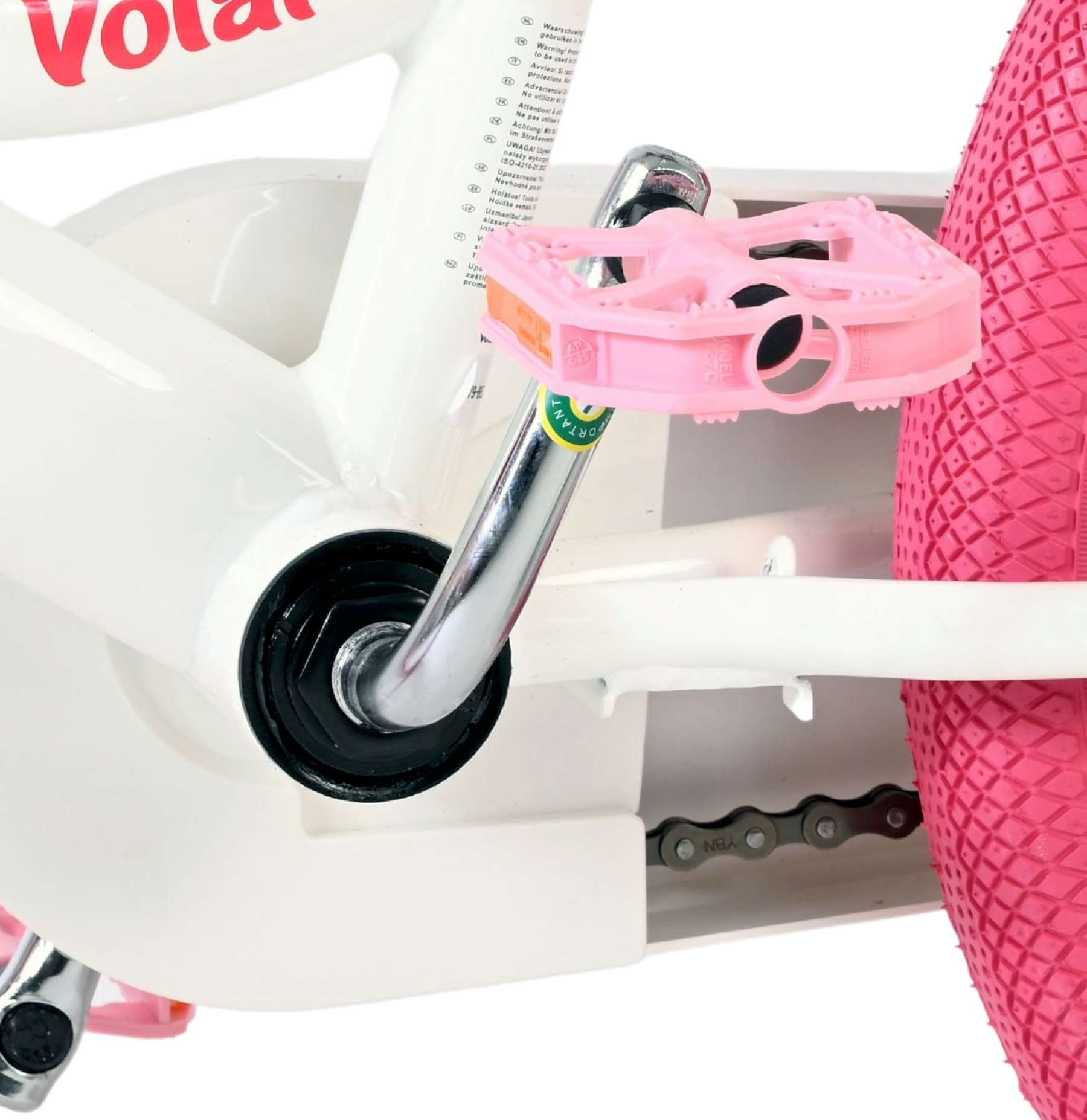Nahaufnahme eines weißen Kinderfahrrads mit rosa Pedalen und Reifen.