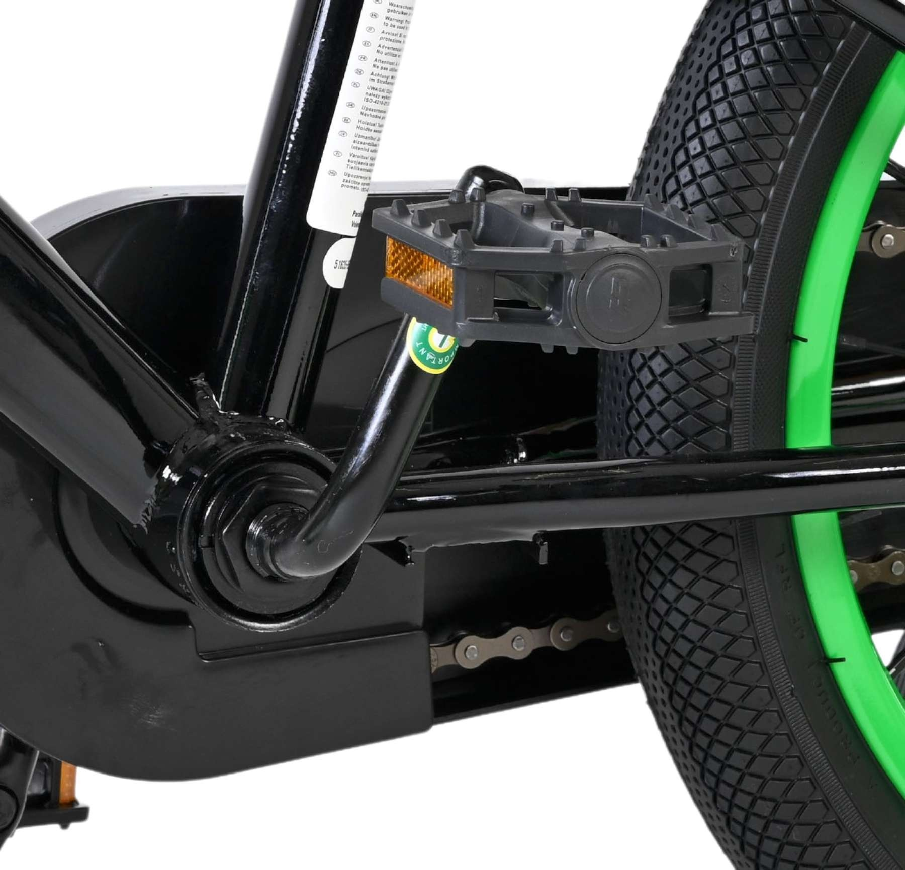 Nahaufnahme des Fahrradpedals, der Kette und des grünen Rads.