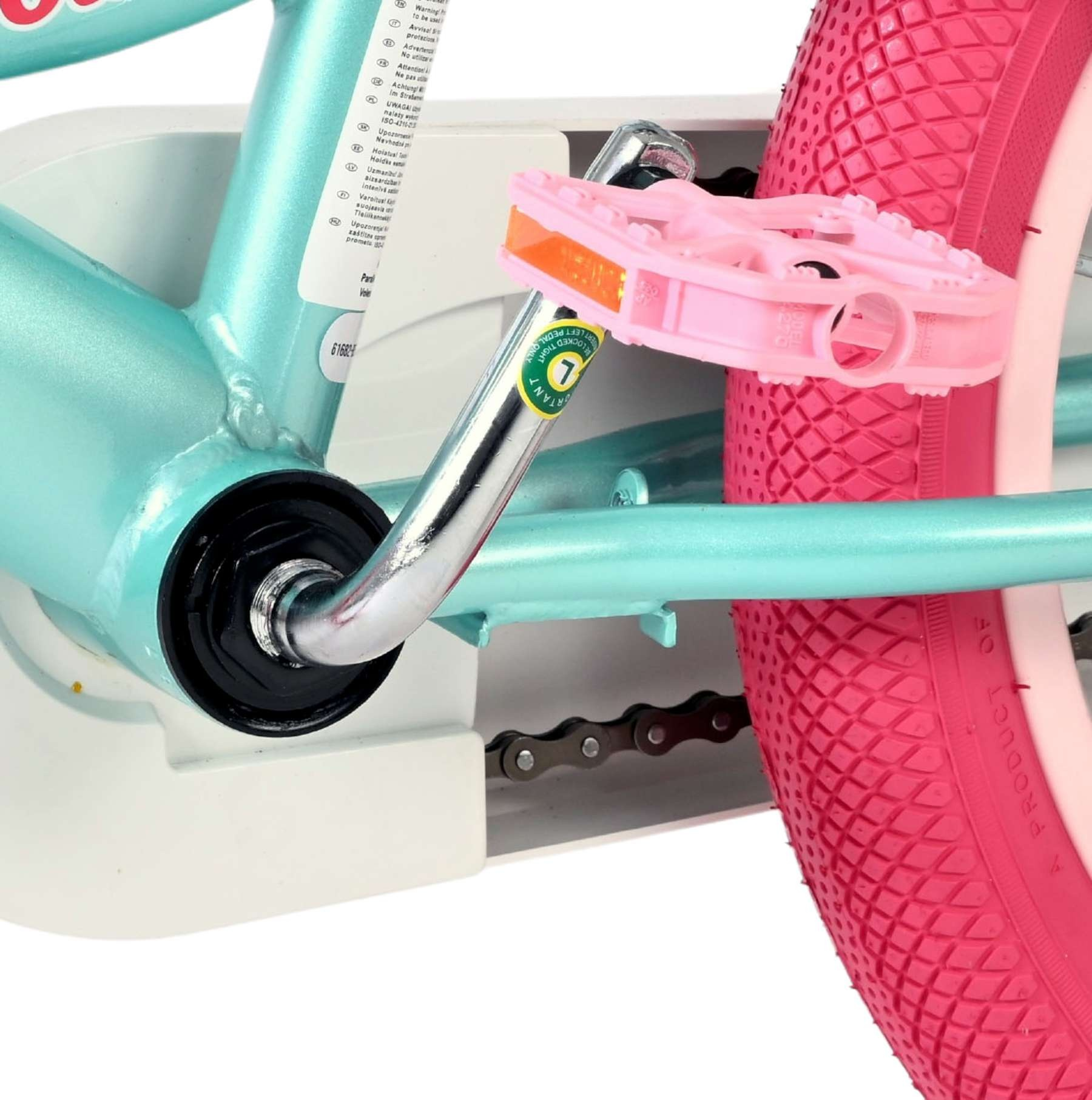 Nahaufnahme eines türkisfarbenen Fahrradrahmens mit rosa Pedalen und Reifen.