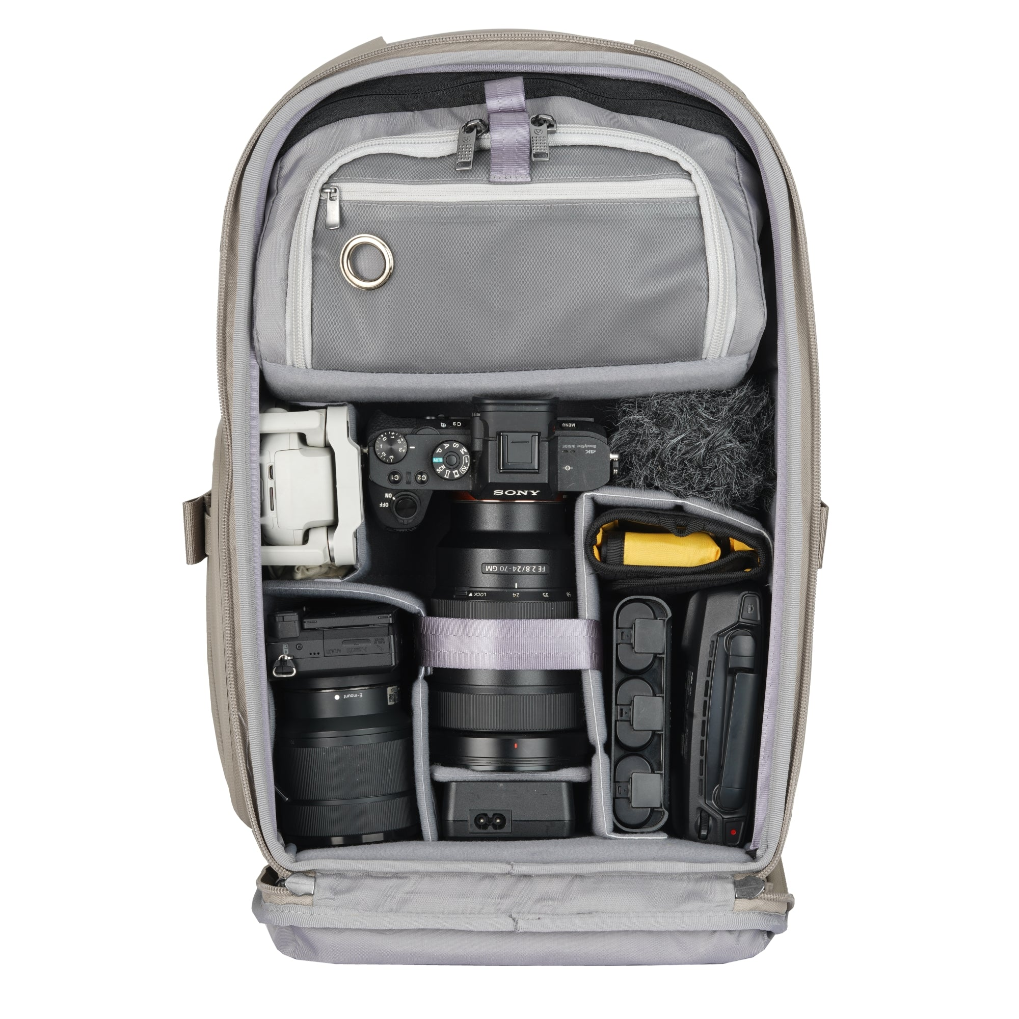 Grauer Rucksack mit Kameraausrüstung: Sony-Kamera, Objektive, Drohne, Mikrofon.