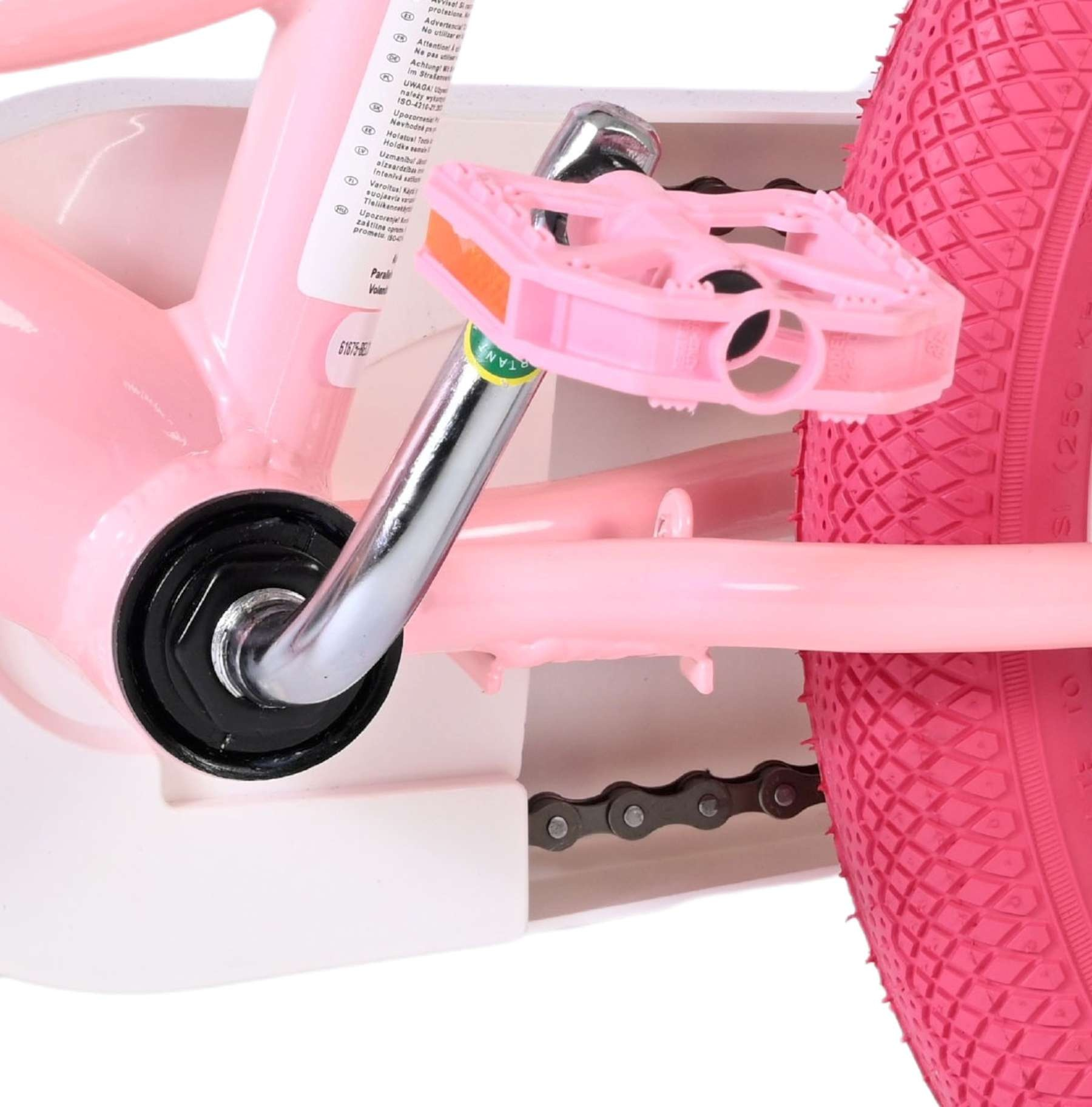 Nahaufnahme eines rosa Kinderfahrrads mit Pedal, Kette und Rad.