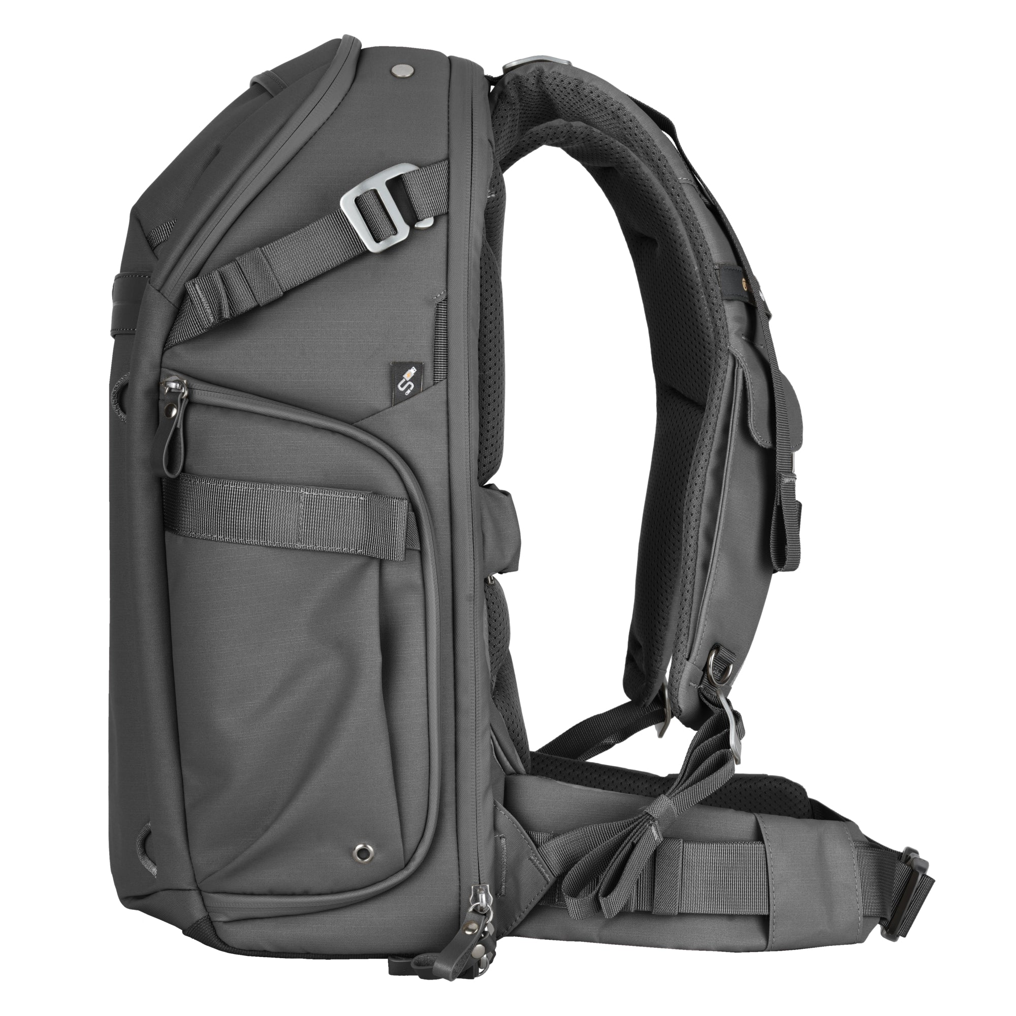 Mochila gris con correas acolchadas y múltiples bolsillos, vista de lado.