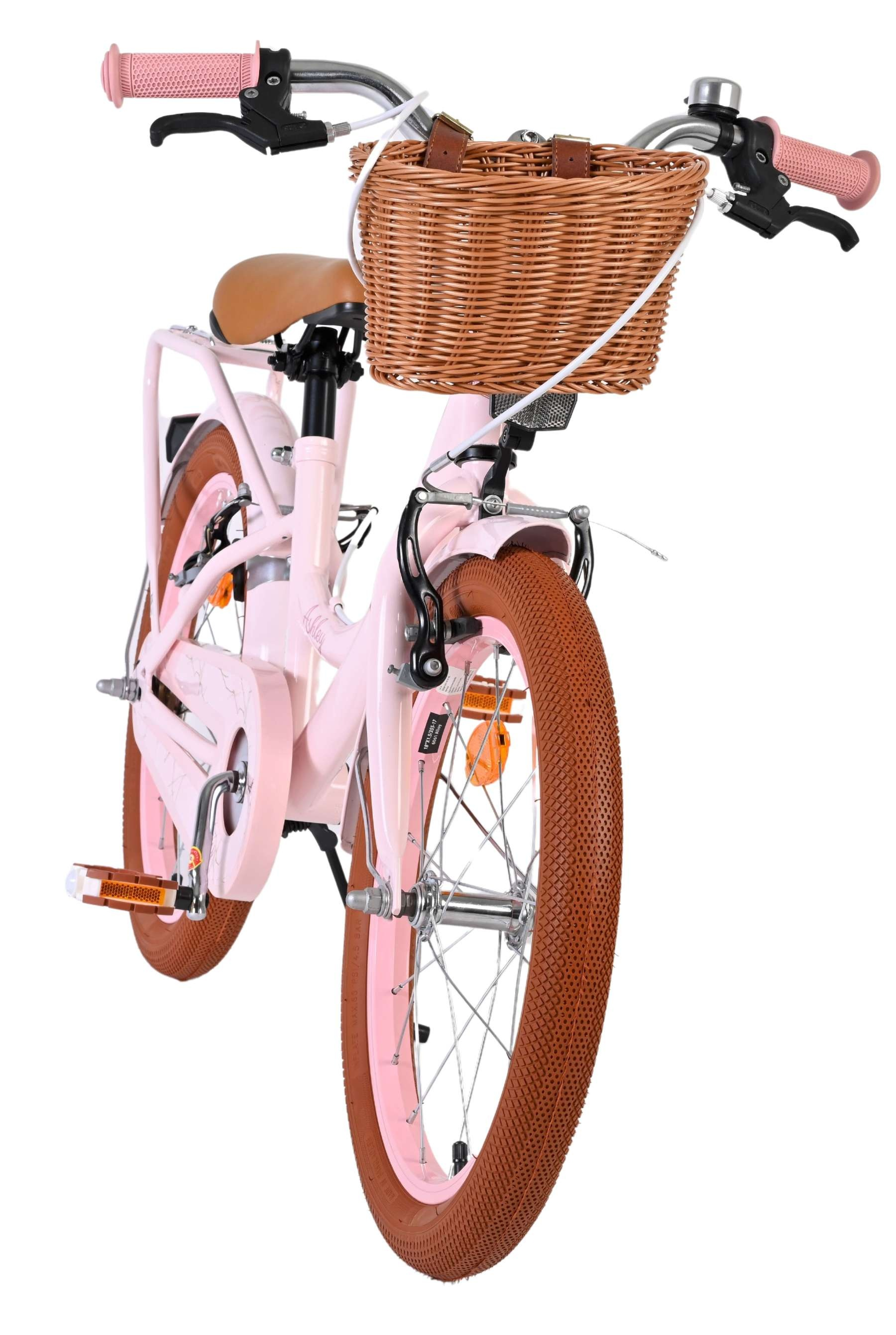 Ein rosa Kinderfahrrad mit braunen Reifen und einem Weidenkorb vorne.