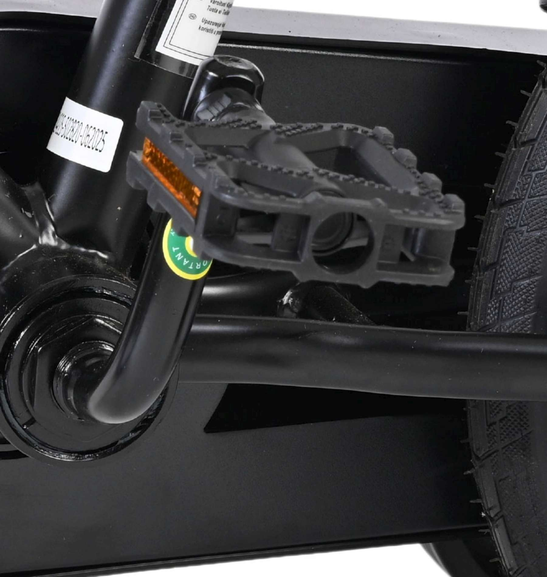 Nahaufnahme eines Fahrradpedals mit Reflektoren, Kurbel und Rad.