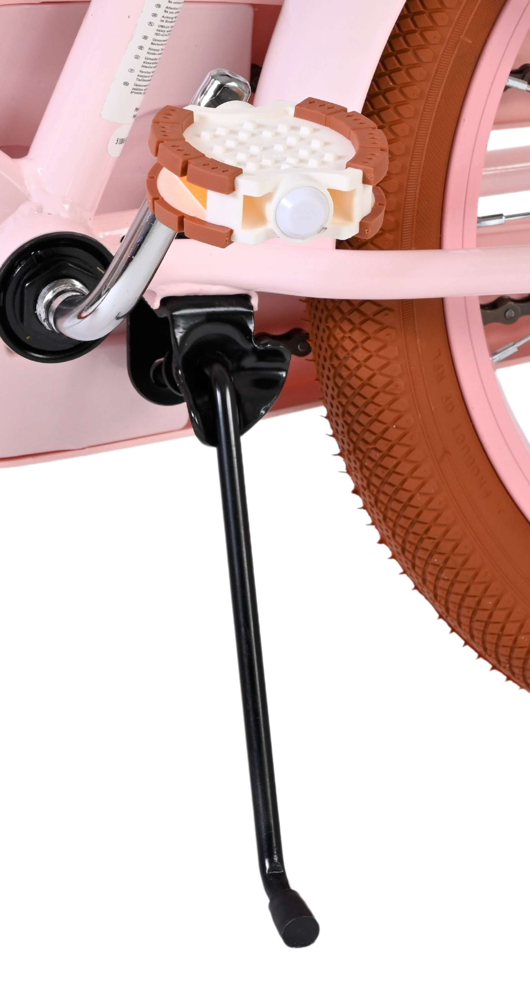 Nahaufnahme eines rosa Fahrradrahmens mit Pedal, Ständer und braunem Reifen.
