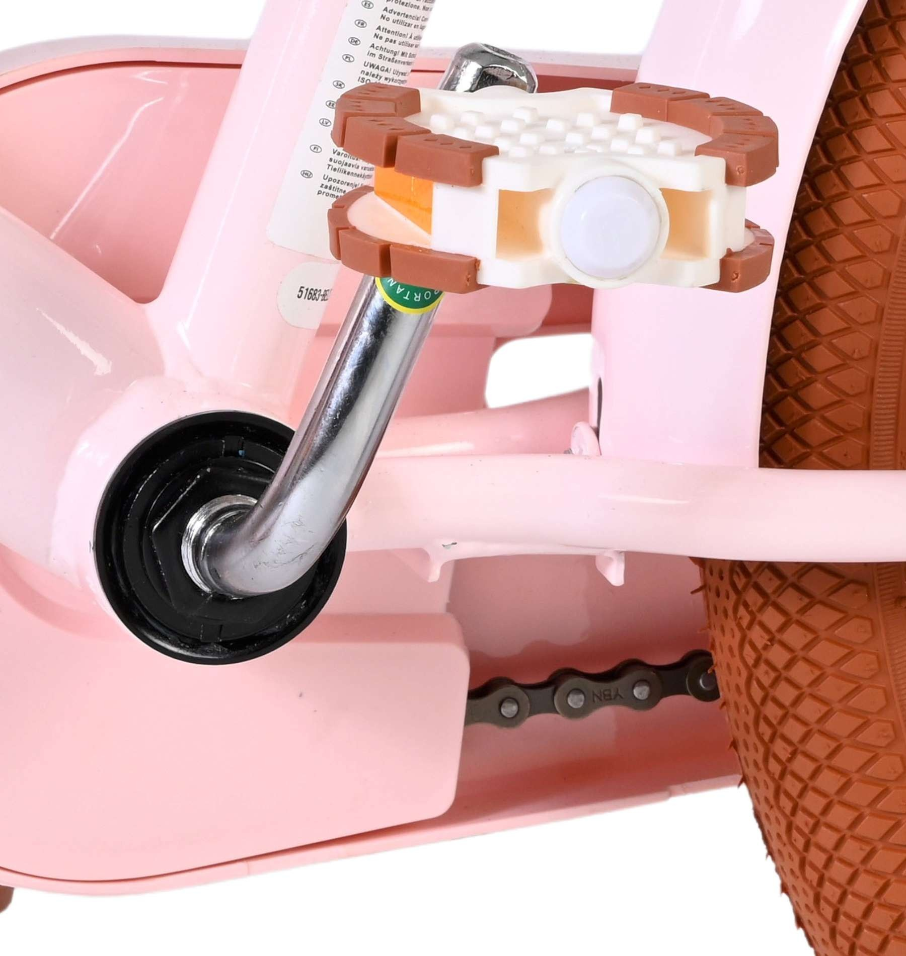 Nahaufnahme eines rosafarbenen Fahrradpedals mit braunem Reifen und Kette.