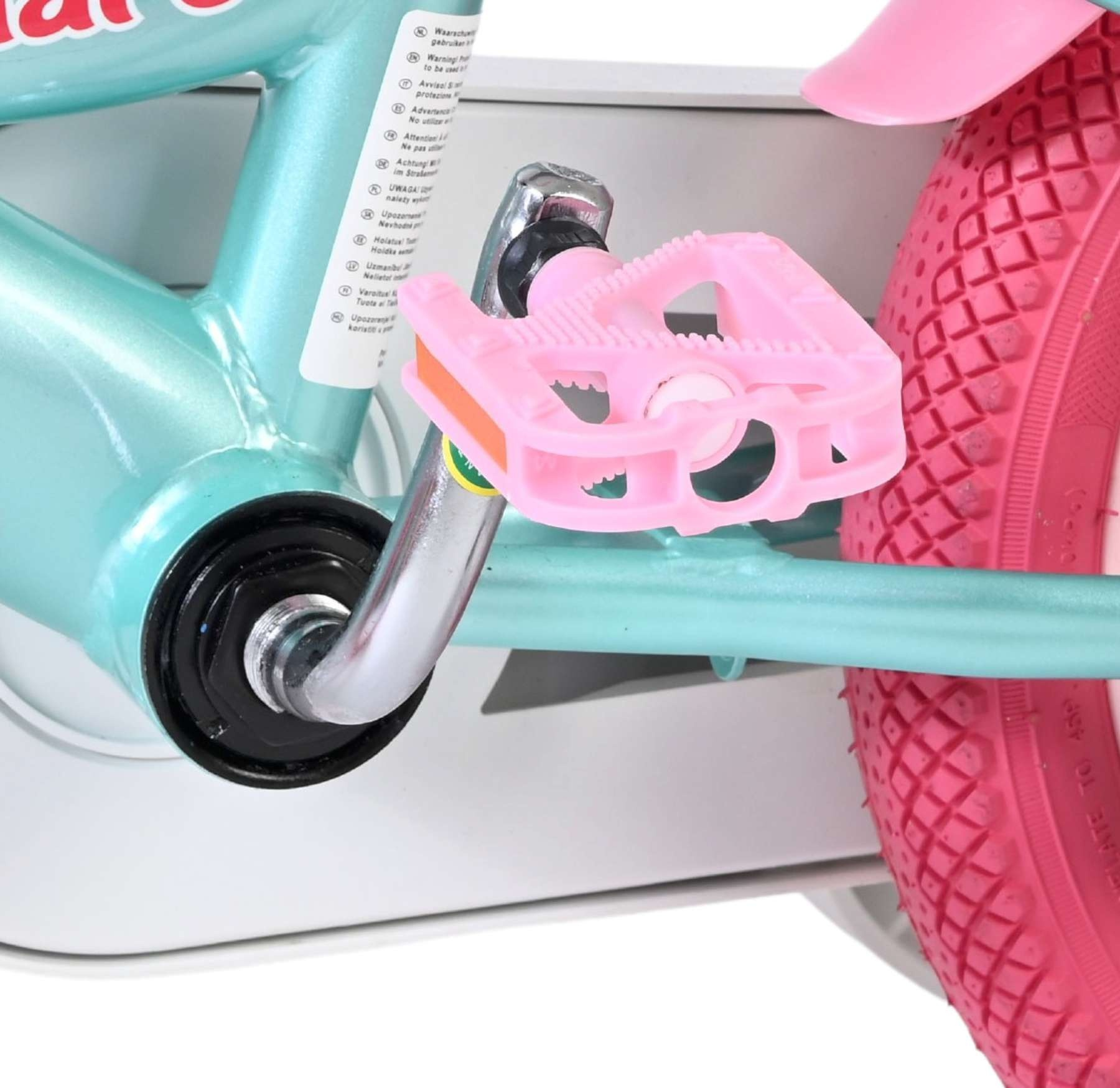 Nahaufnahme eines türkisfarbenen Fahrradrahmens mit rosa Pedalen und Rad.