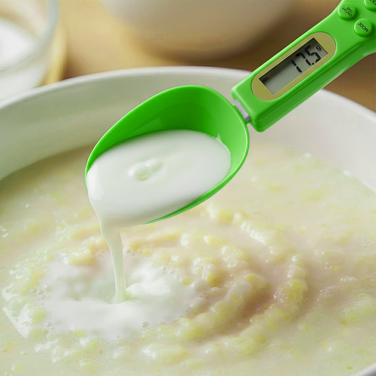 Grüner Löffel mit Milch über einer Schüssel mit Müsli, digitales Display zeigt 17.5.