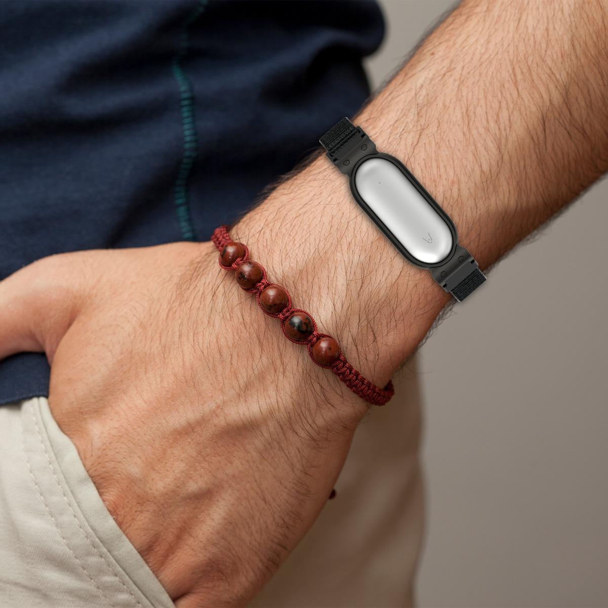 Un uomo indossa un braccialetto con perle rosse e un fitness tracker.