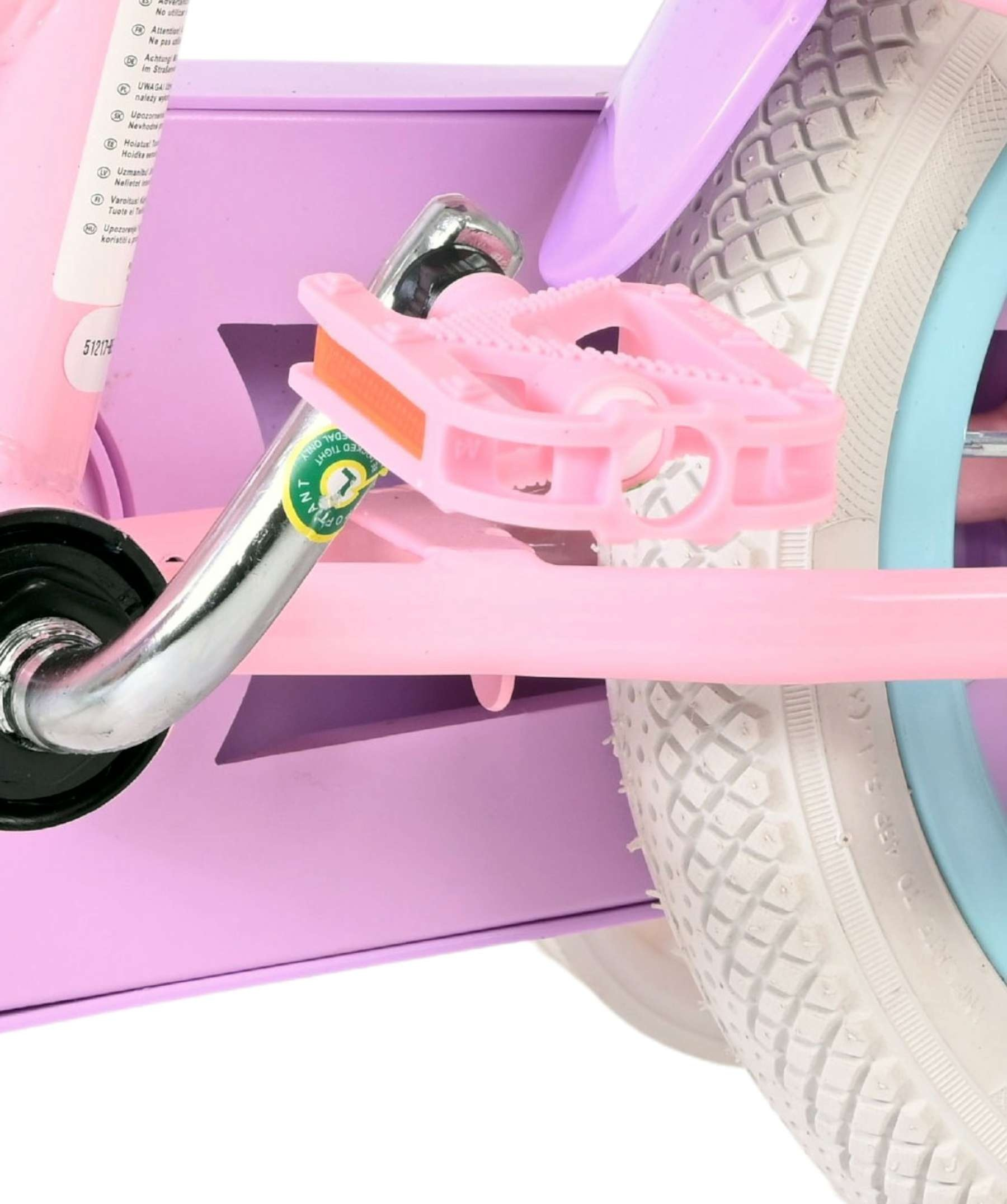 Nahaufnahme eines pinken Fahrradpedals und eines weißen Reifens mit lila Rahmen.