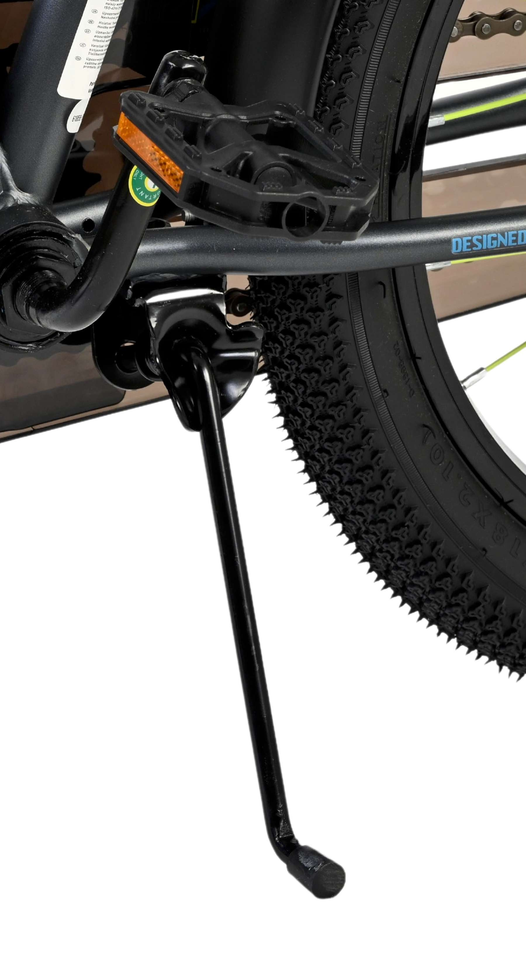 Nahaufnahme des Fahrradständers, Pedals und Reifens. Schwarze Metallteile.